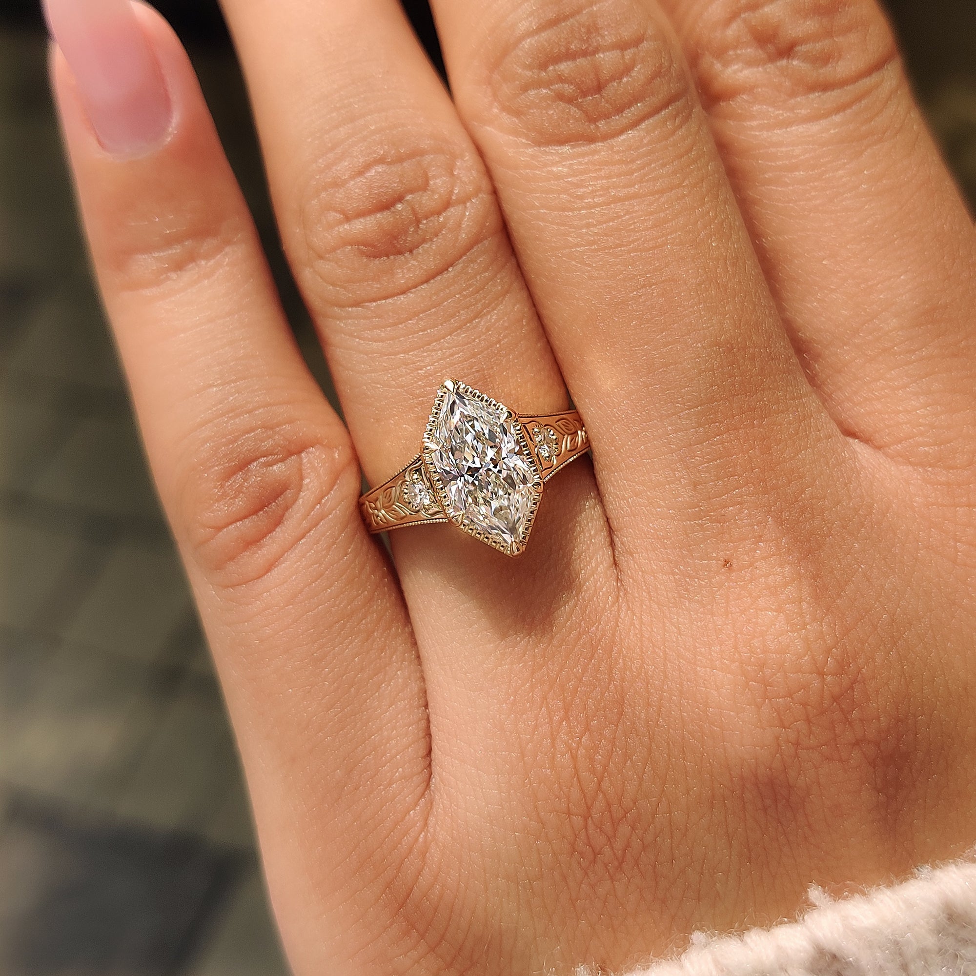 Floral engraving and milgrain details on the three stone ring.
