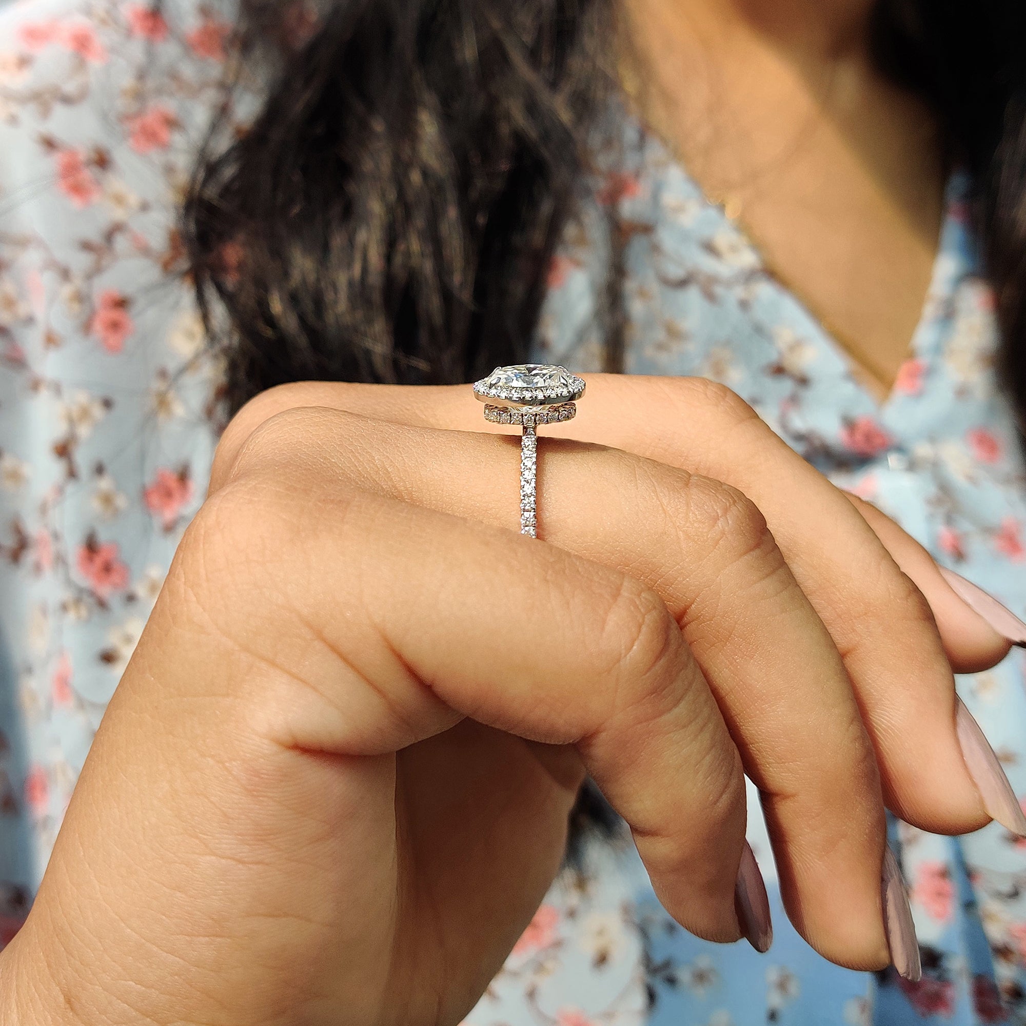 The pave set ring adds continuous sparkle with small stones around the band.
