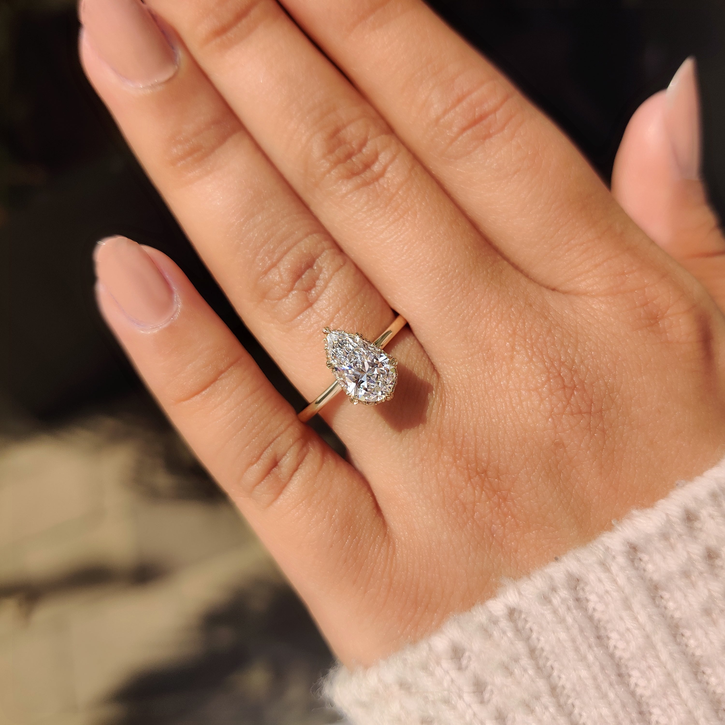 Solitaire pear diamond ring with round halo accent.
