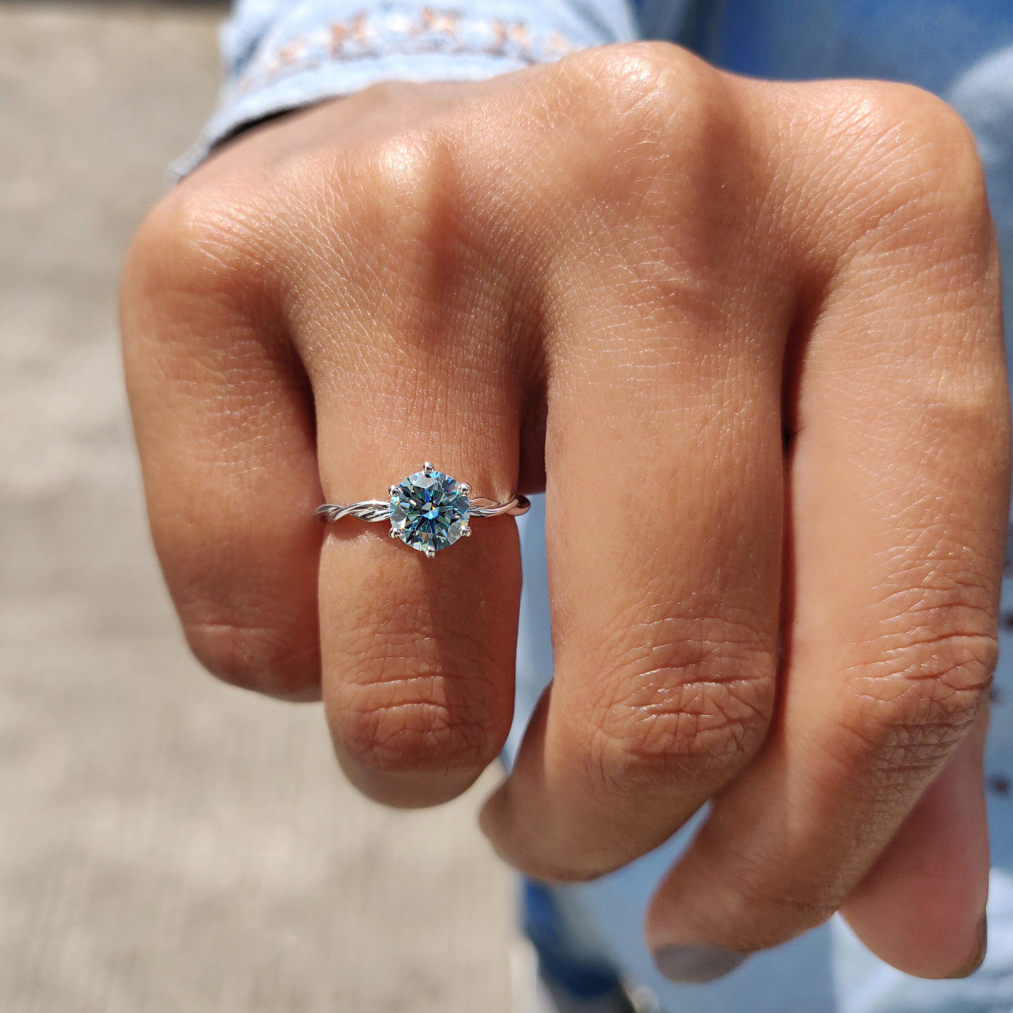 A solitaire gold ring brings warmth and elegance to the design.
