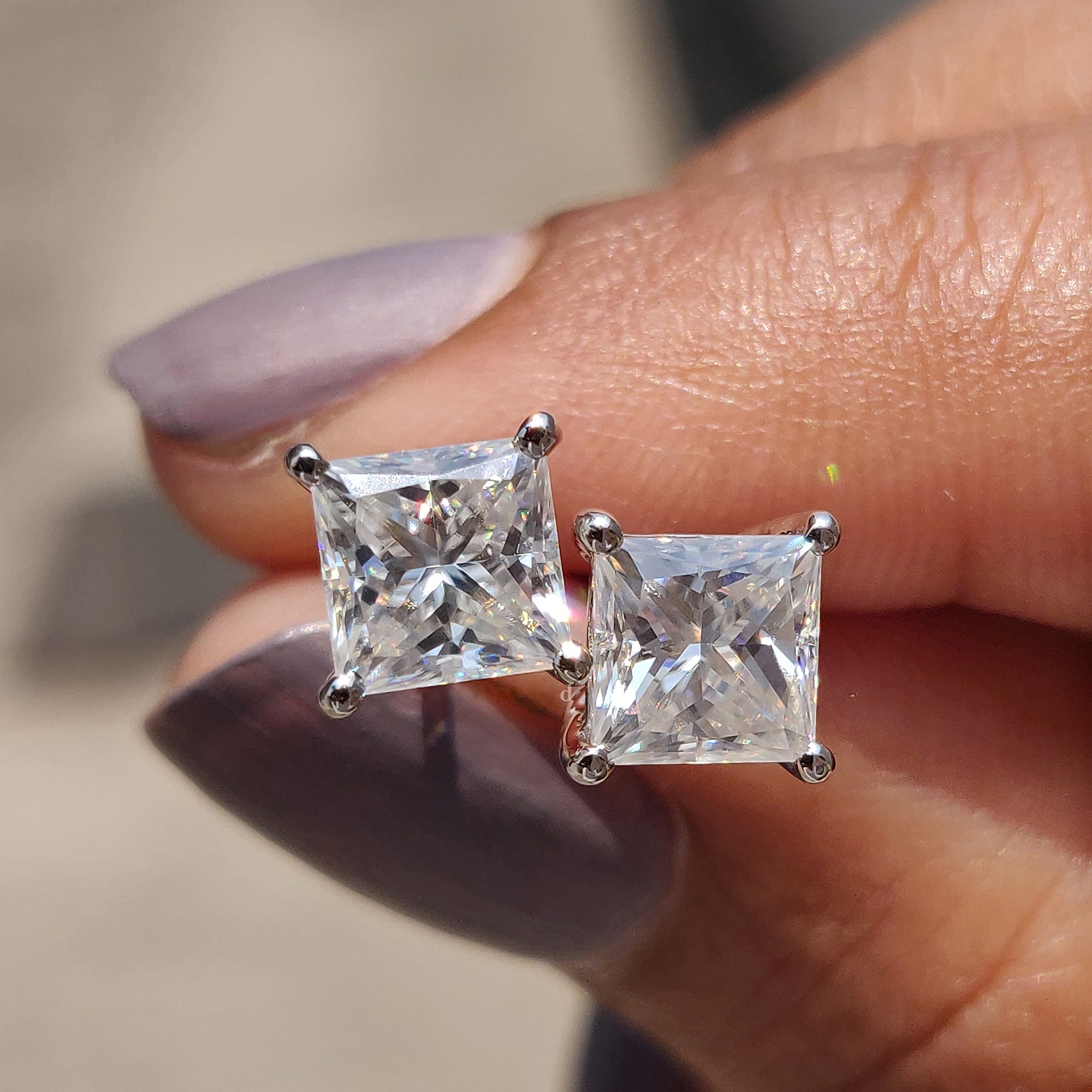 Princess cut Moissanite Earrings crafted in white gold earrings with 4 prong setting and push back earrings.
