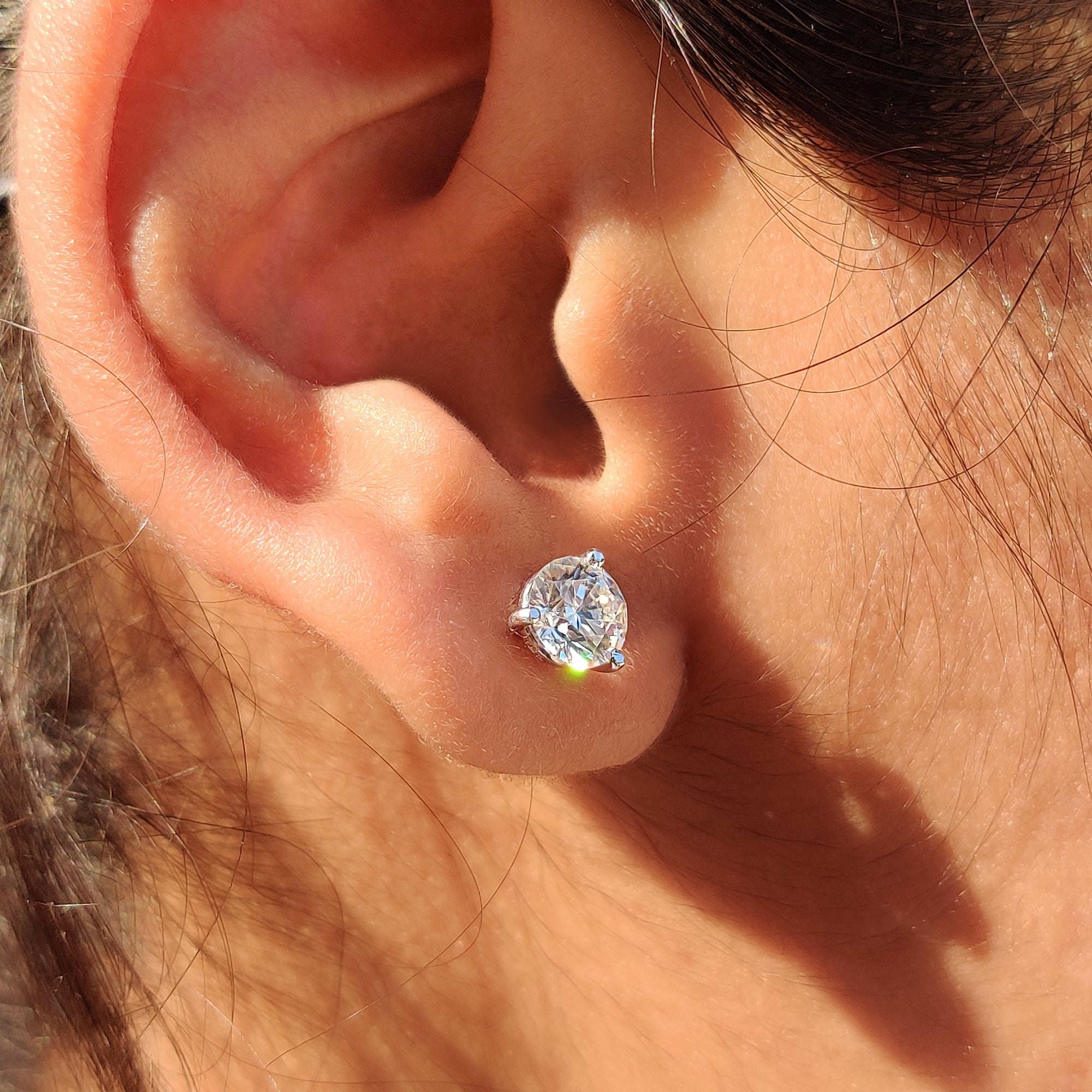 Round cut Moissanite Earrings designed as Moissanite Stud Earrings with martini style earrings setting.
