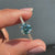 This cyan blue round cut ring pairs beautifully with a pave setting for a clean and stylish design.