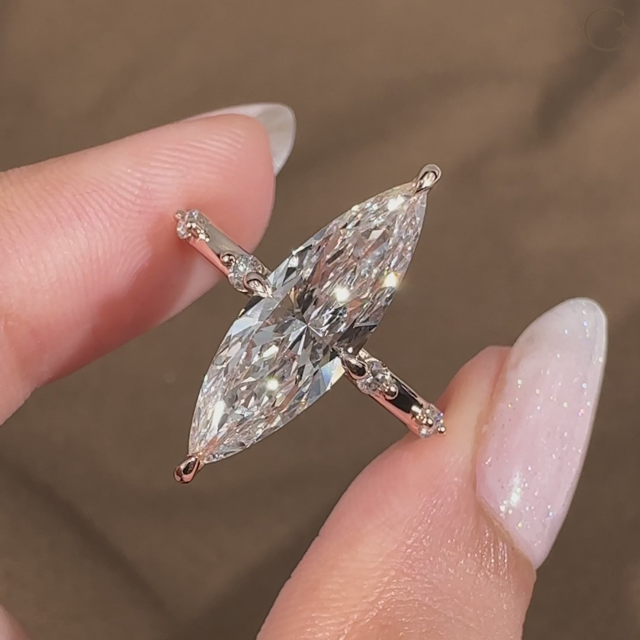 Marquise diamond ring with compass prongs and pave band
