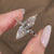 Marquise diamond ring with compass prongs and pave band
