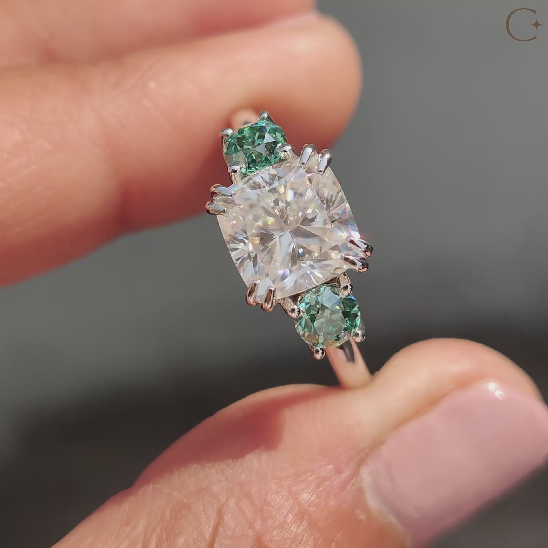 White gold Moissanite ring with green round side stones.