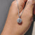 Round diamond pendant in a white gold halo setting.
