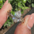 Pear diamond ring featuring marquise and round side stone accents.
