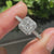 White gold engagement ring with four prong setting and halo design.
