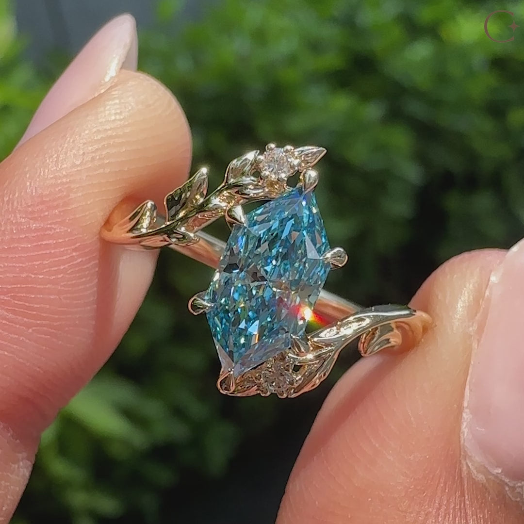 Nature inspired blue Dutch marquise ring with round diamond leaf accents.
