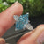 Basket setting holding blue dutch marquise center diamond and pear side stones
