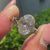 Three stone engagement ring with an oval cut center diamond.
