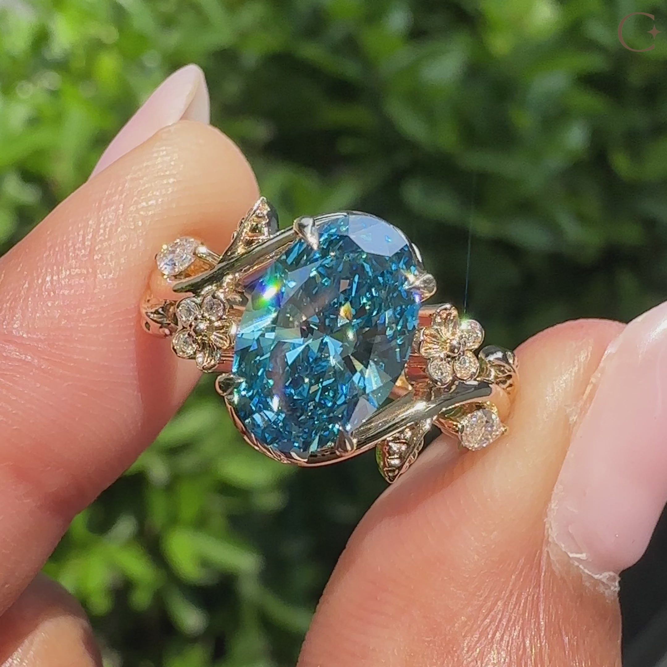 Green oval diamond solitaire ring with oak leaf details.
