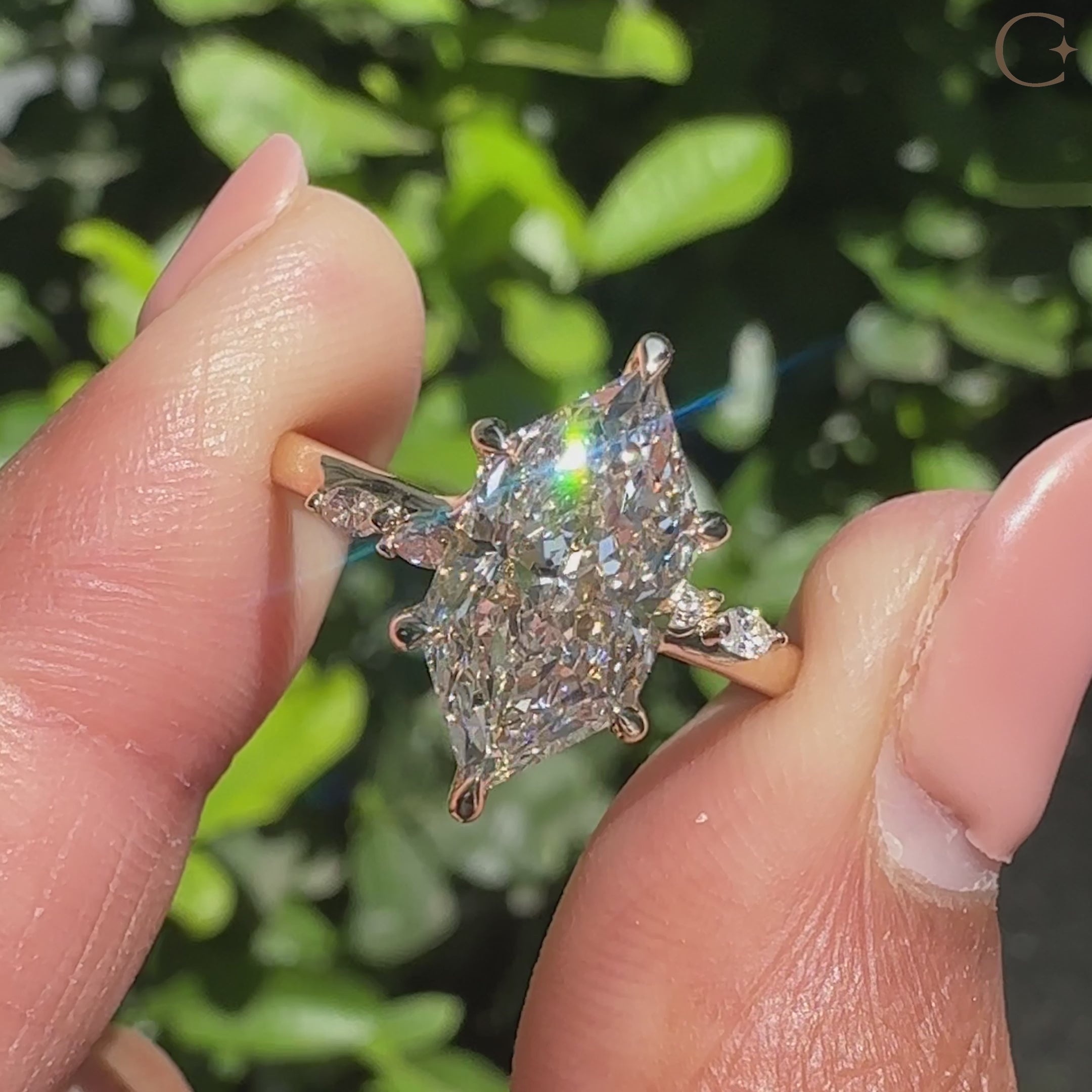 Marquise diamond ring with round bridge accent detail.
