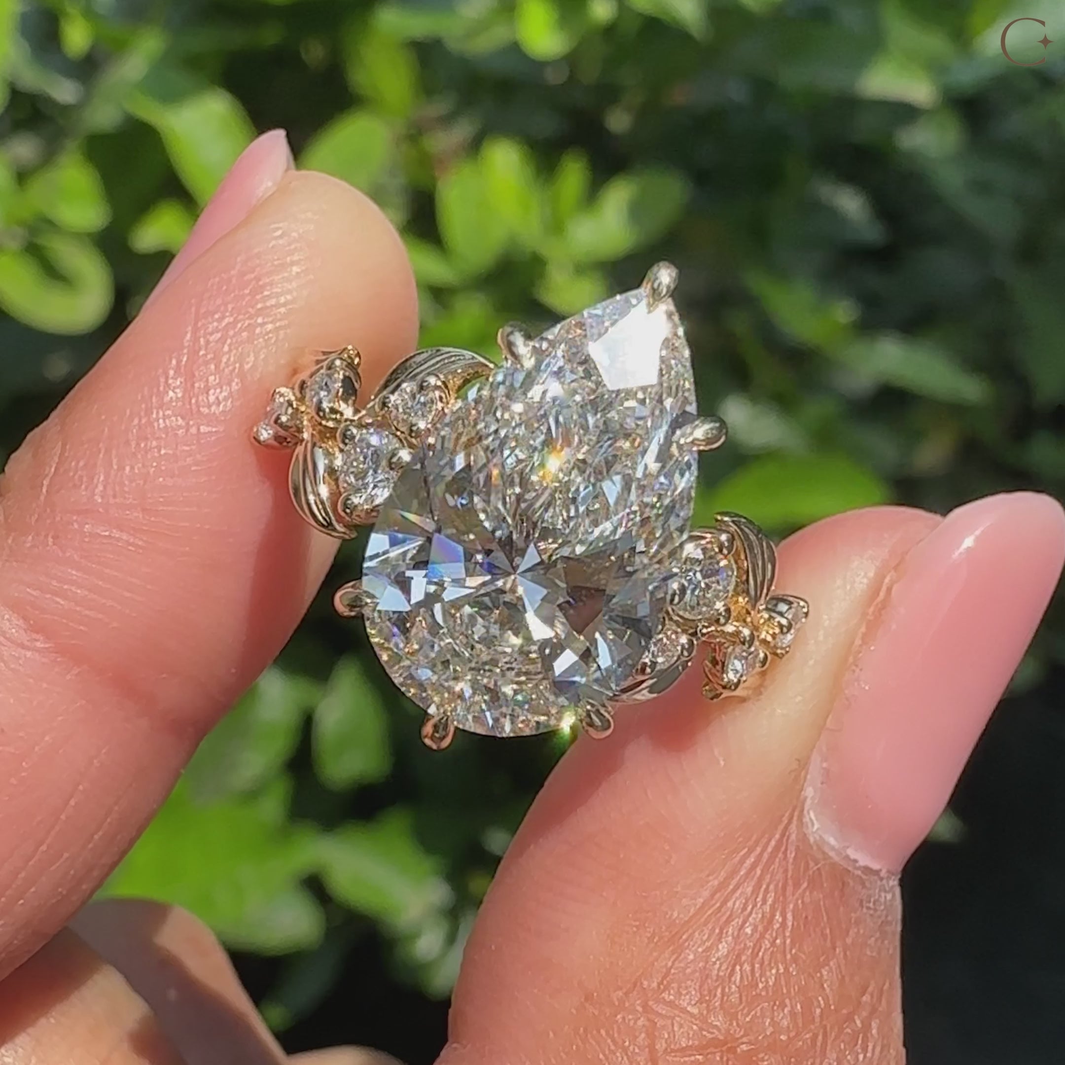 Pear shaped diamond ring designed with round side stones for added depth
