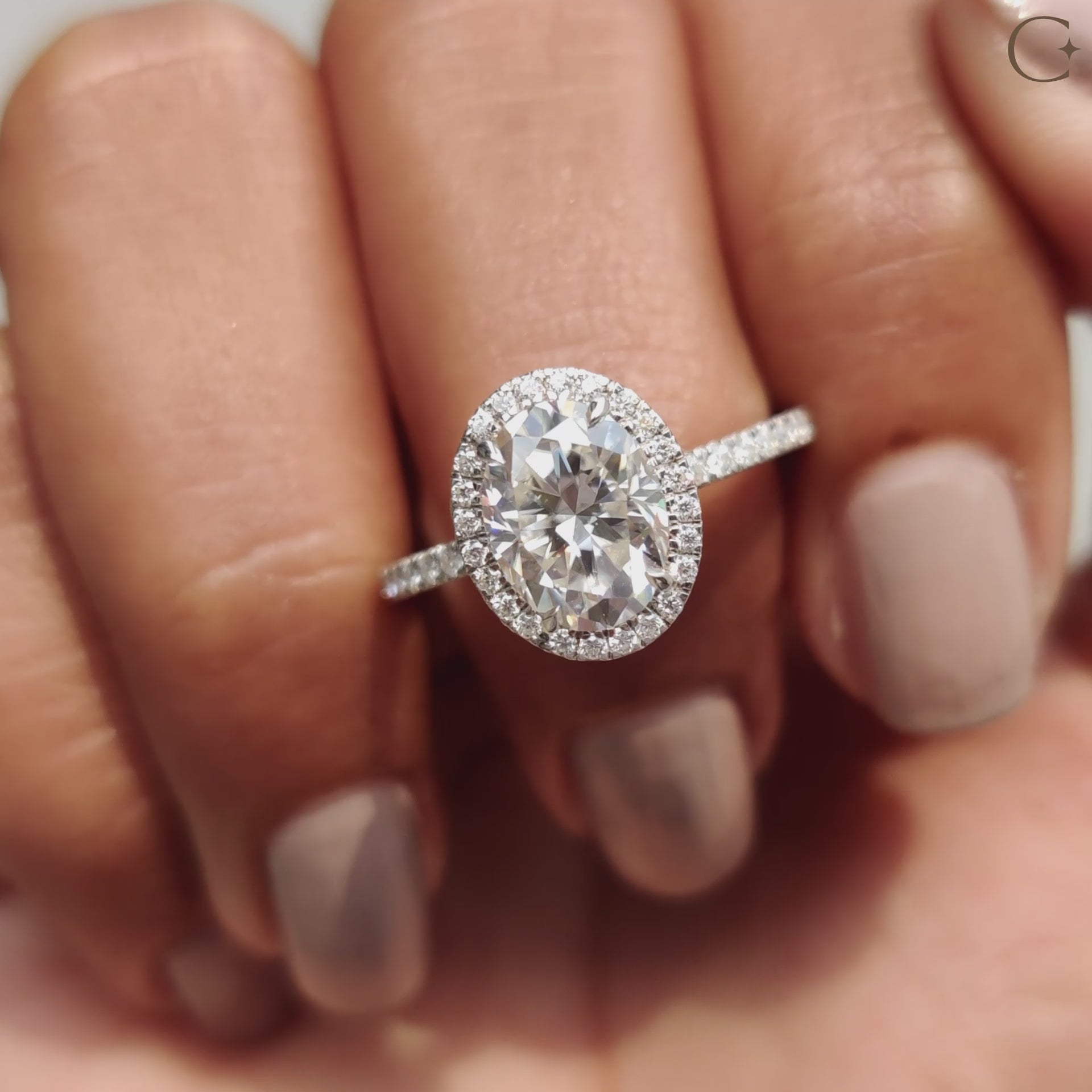 An oval hidden halo engagement ring adds a modern touch to a classic design.
