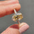 Yellow gold engagement ring featuring an oval cut Moissanite stone with round cut side stones.