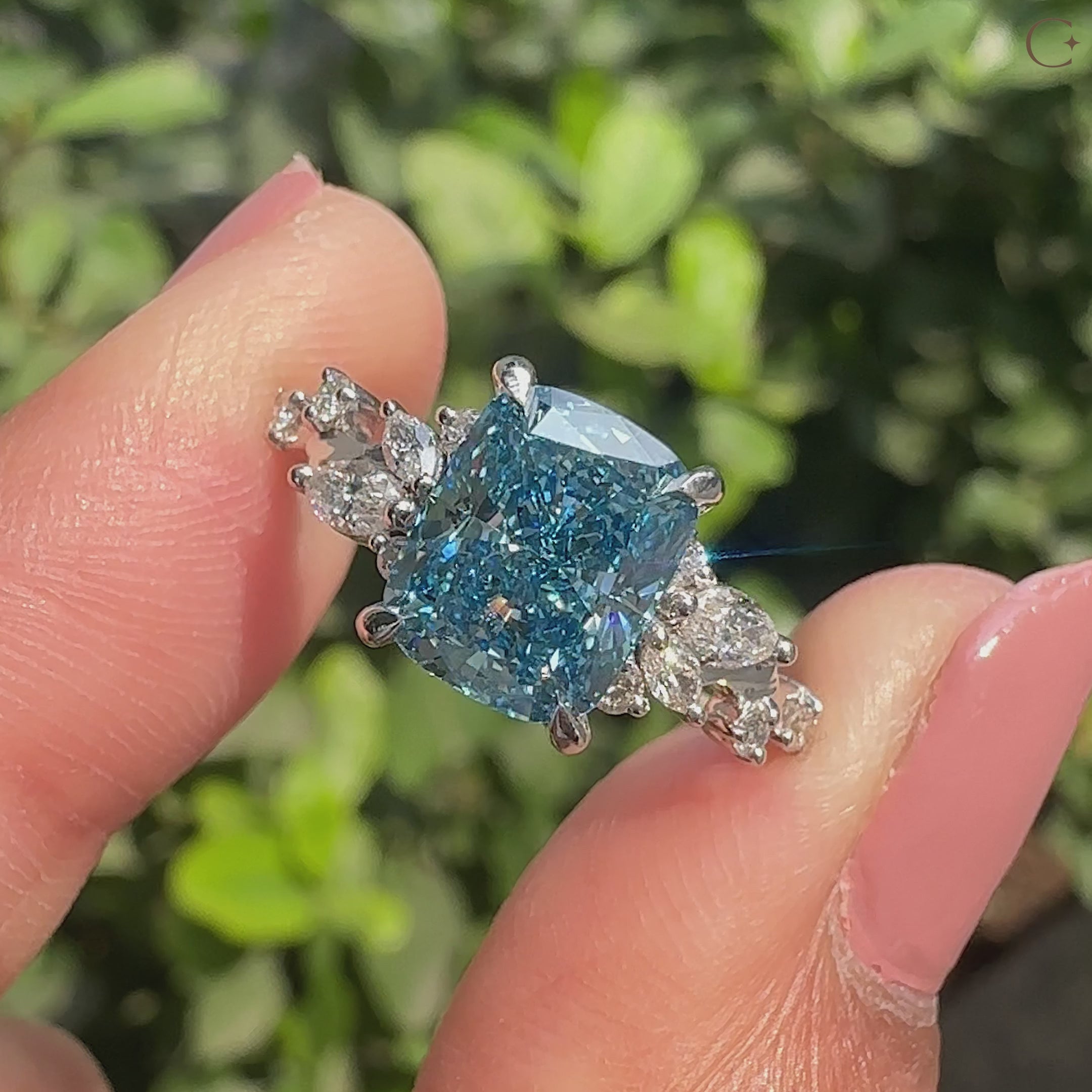 Blue cushion cut diamond ring with marquise and round side stones.
