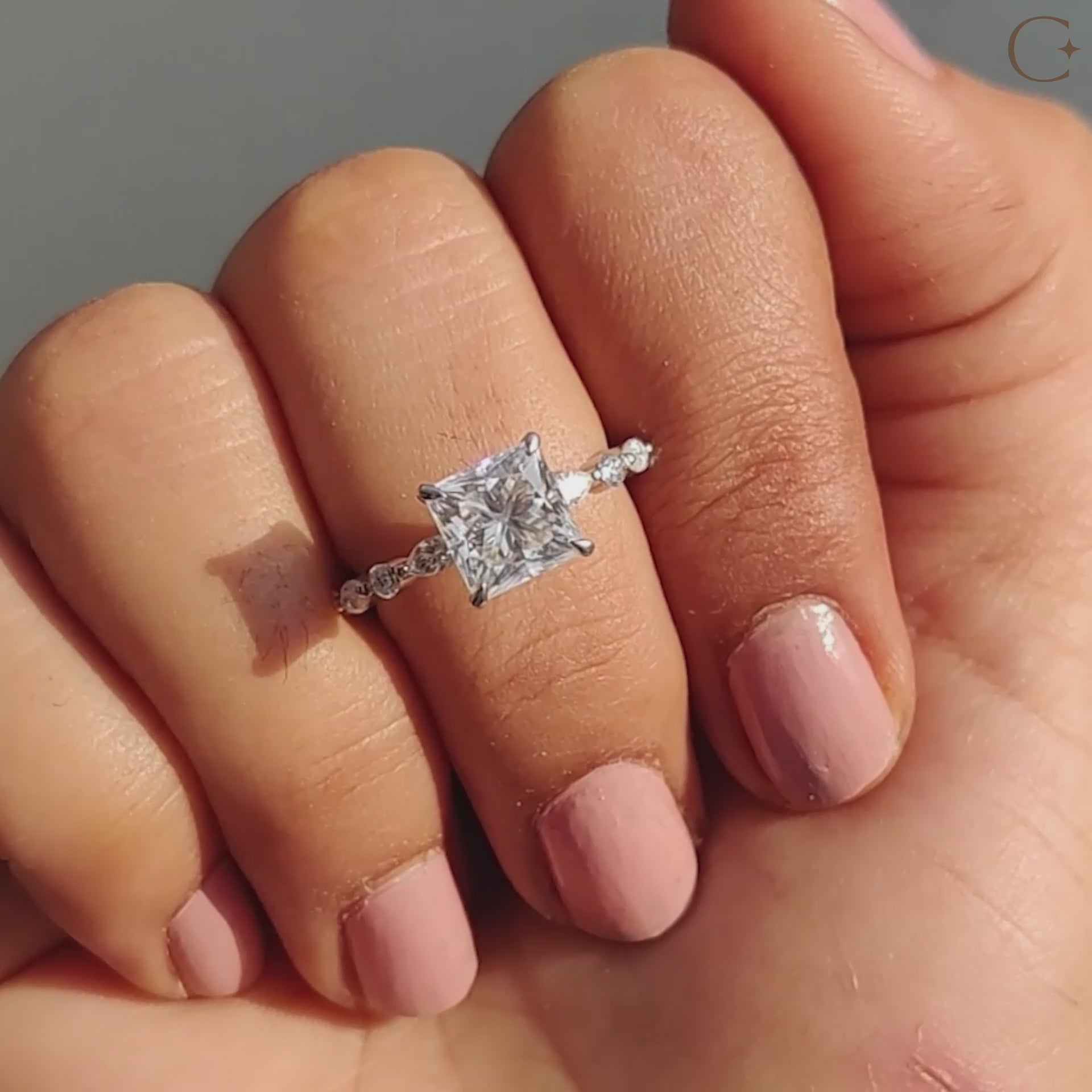 Princess cut moissanite ring shown in soft light.