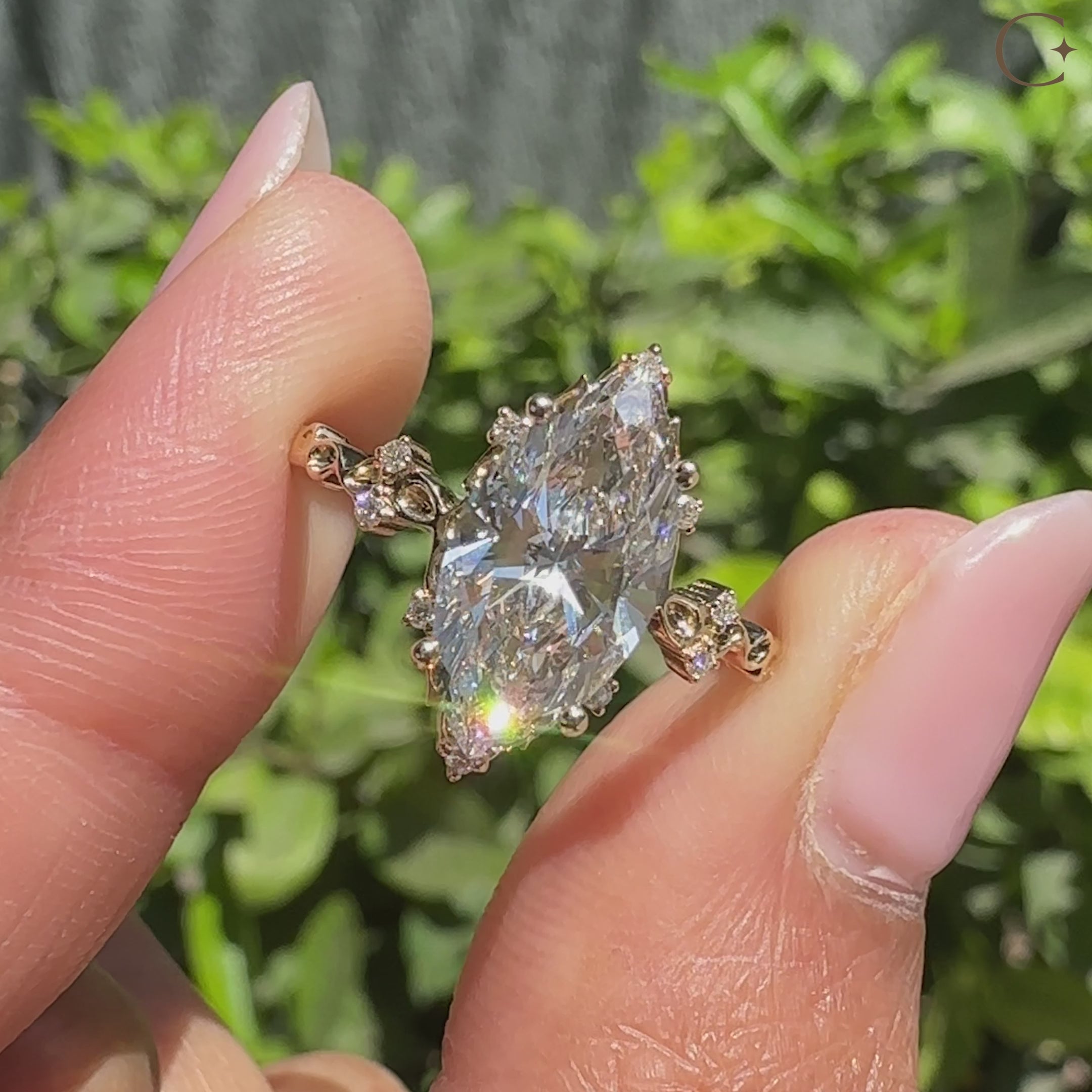 Marquise diamond ring with cluster setting and round accents.
