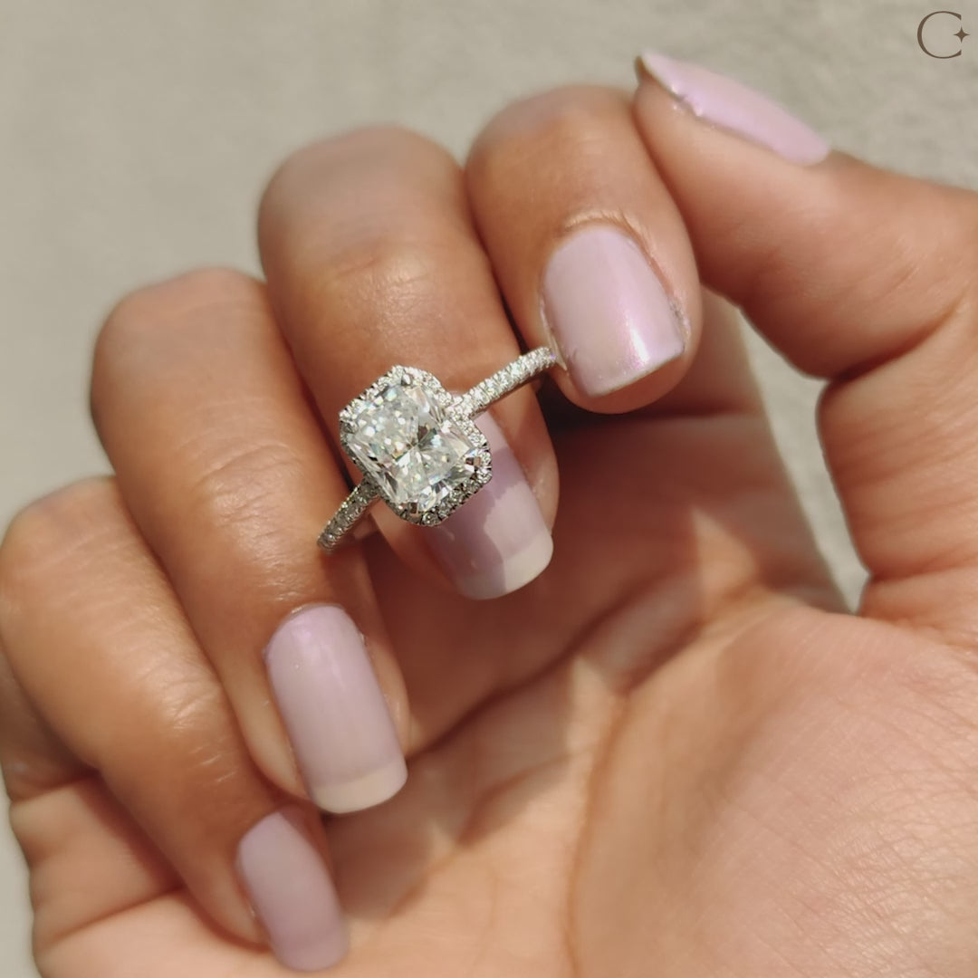 White gold engagement ring with a radiant and round cut moissanite.