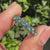 Blue round moissanite half eternity band with shared prongs.
