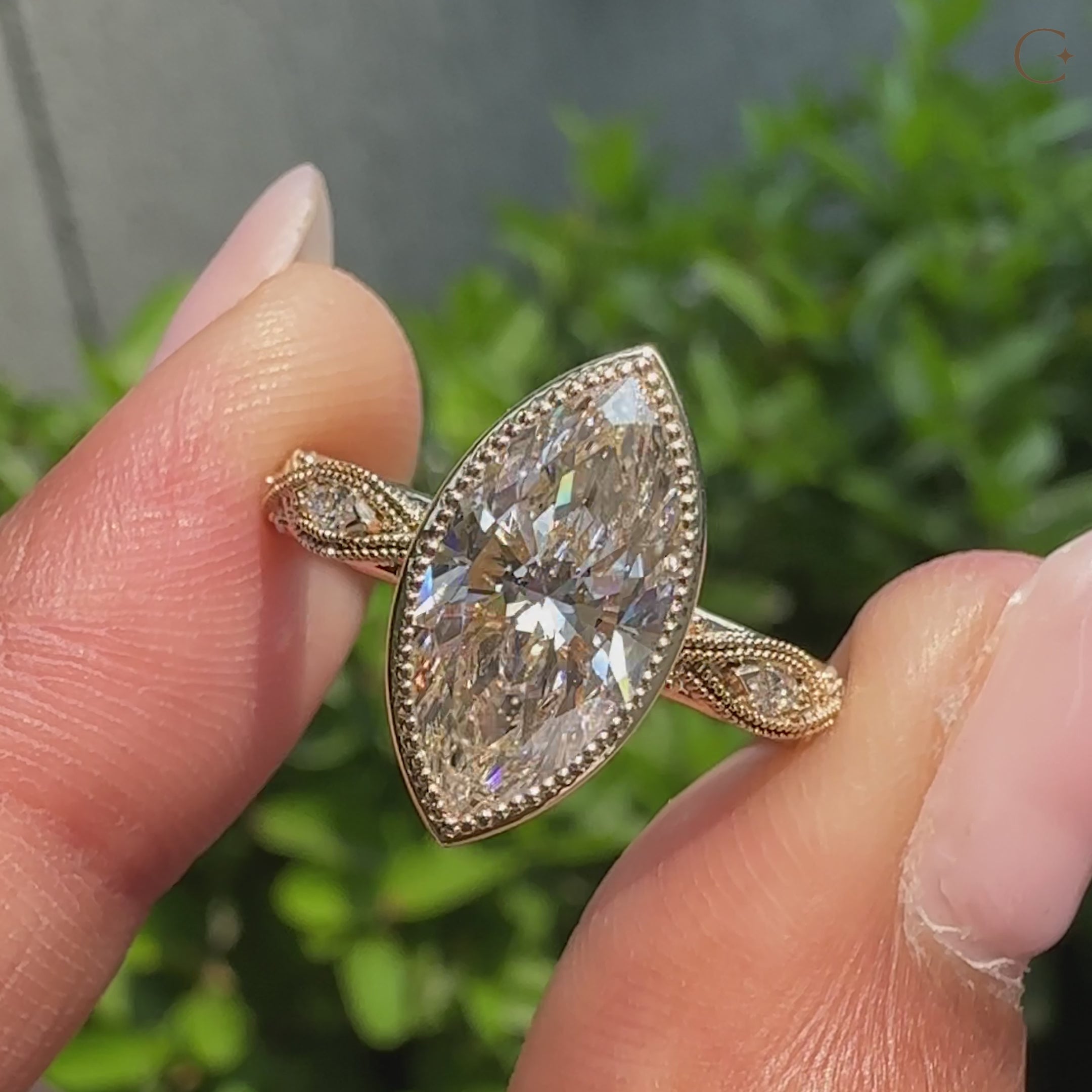 Marquise cut center diamond framed by a dotted bezel edge.
