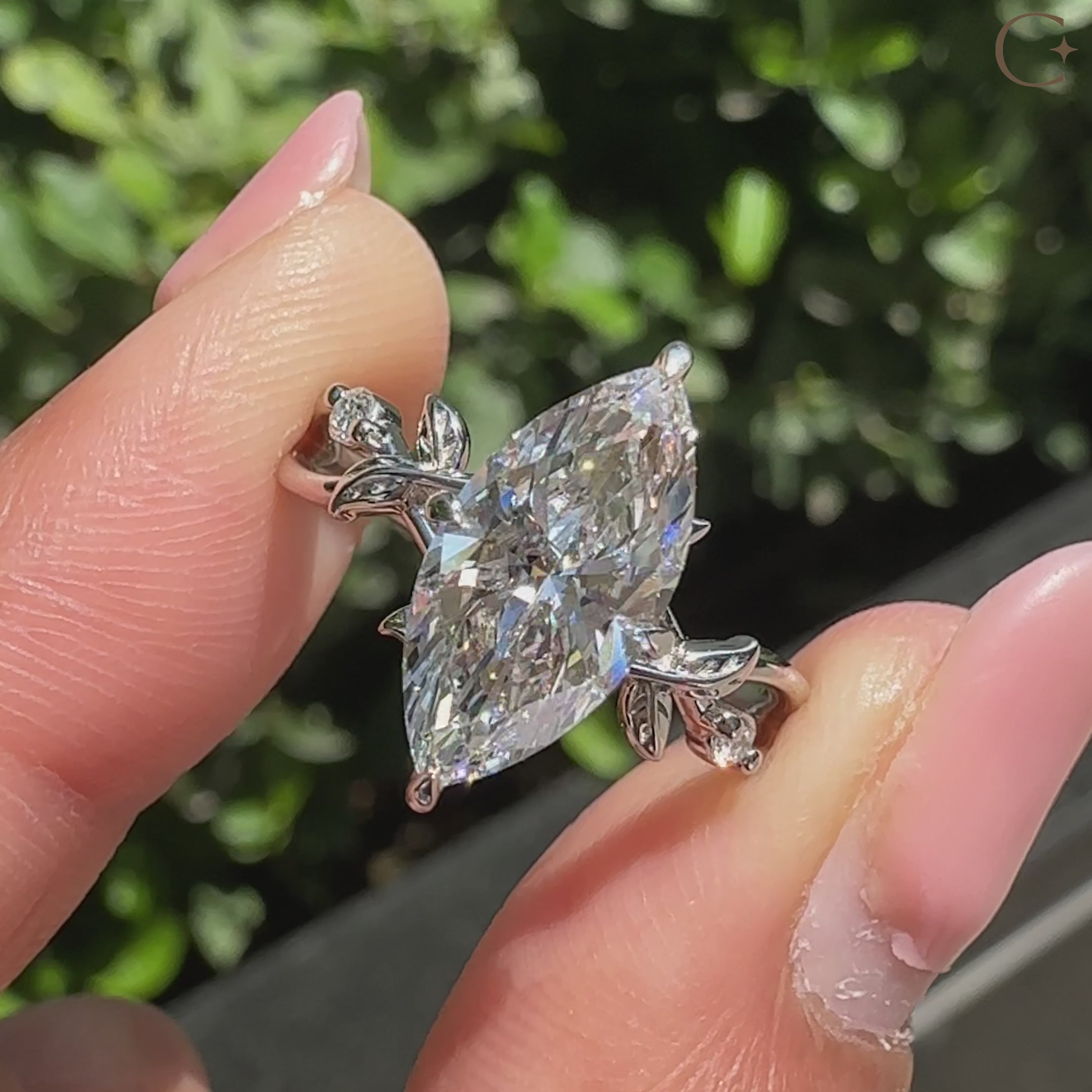 Marquise diamond ring with round side stones and halo.
