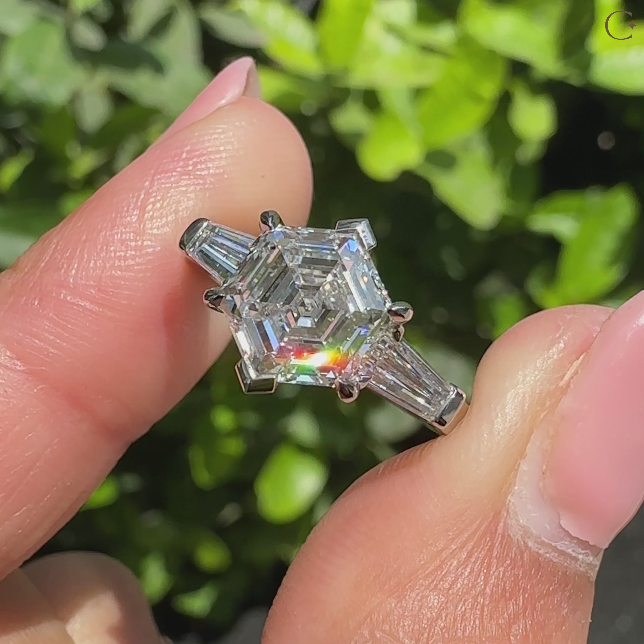 Three stone diamond ring with geometric hexagon center stone.
