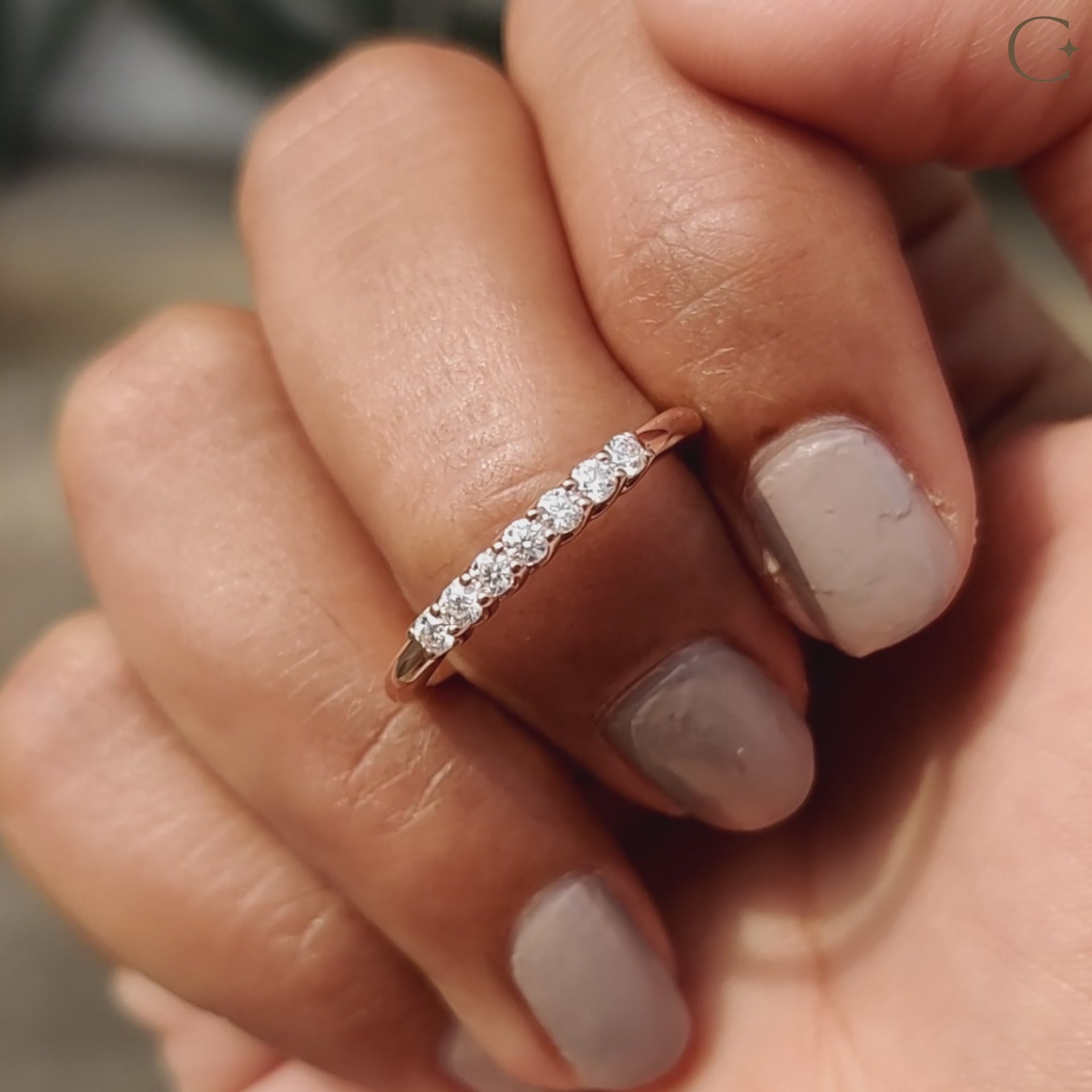 Round moissanite wedding band crafted in rose gold for a modern yet elegant look.