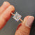 Elegant cathedral setting white gold engagement ring featuring a dazzling princess cut Moissanite stone.