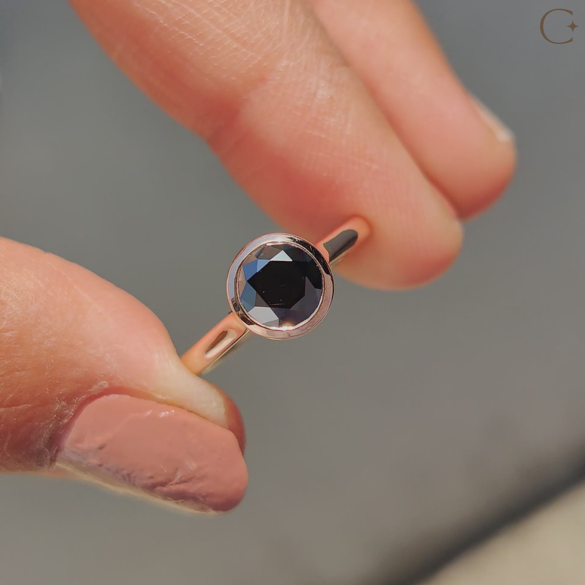 Solitaire engagement ring featuring a black round cut Moissanite in rose gold.