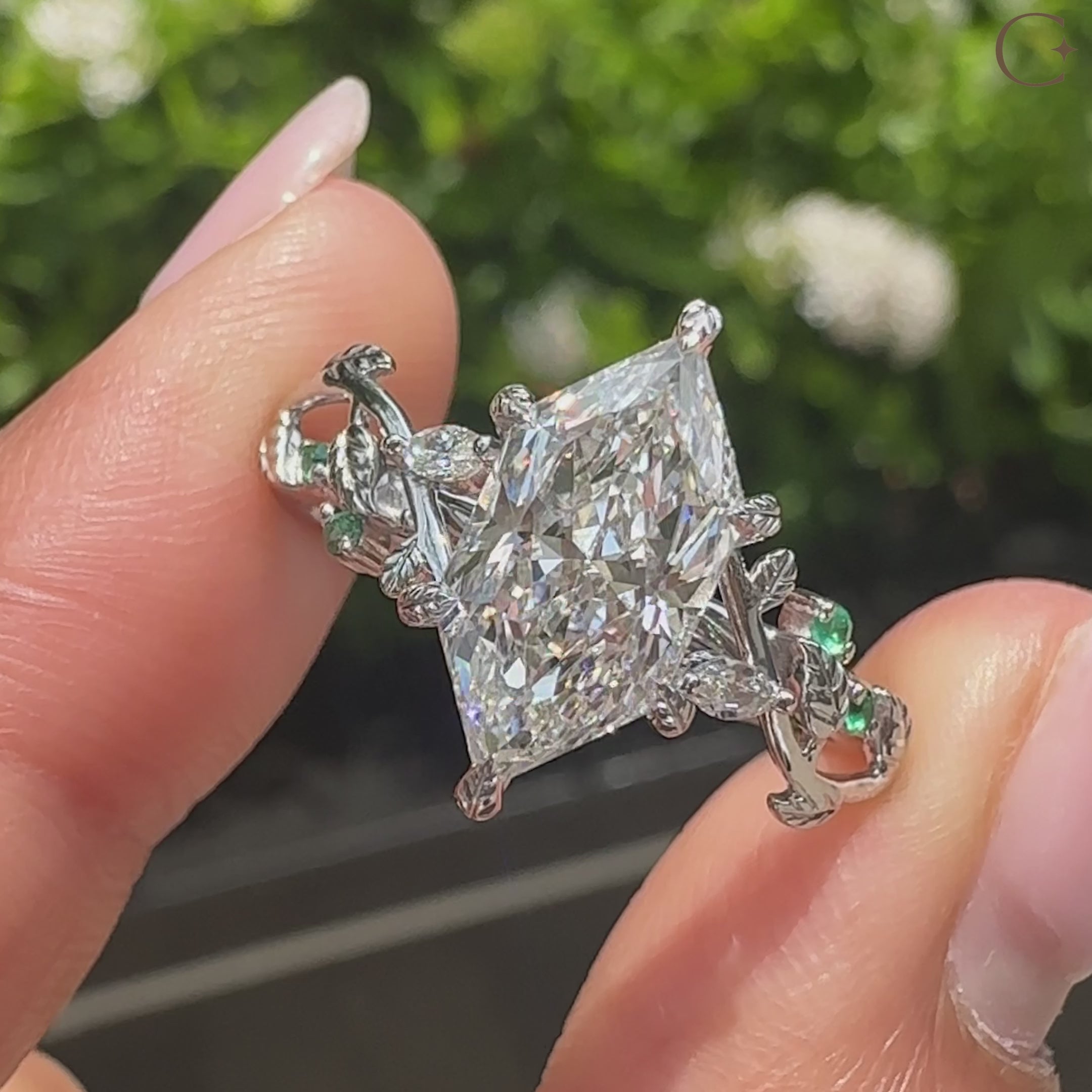Nature style diamond ring with green gemstones and prongs
