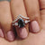 Pear cut engagement ring with black Moissanite and round side stones.
