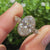 Oval bezel engagement ring with marquise and round side stones

