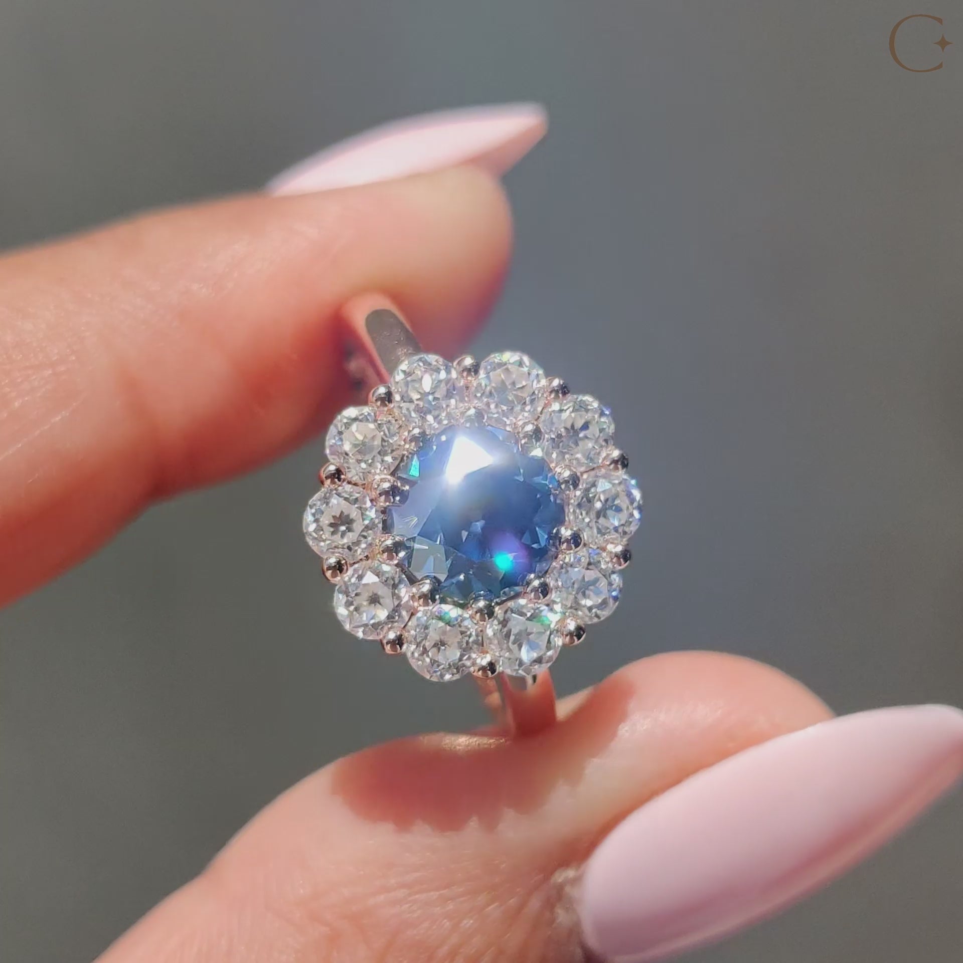 Cluster halo engagement ring featuring a round cut stone surrounded by sparkling diamonds.
