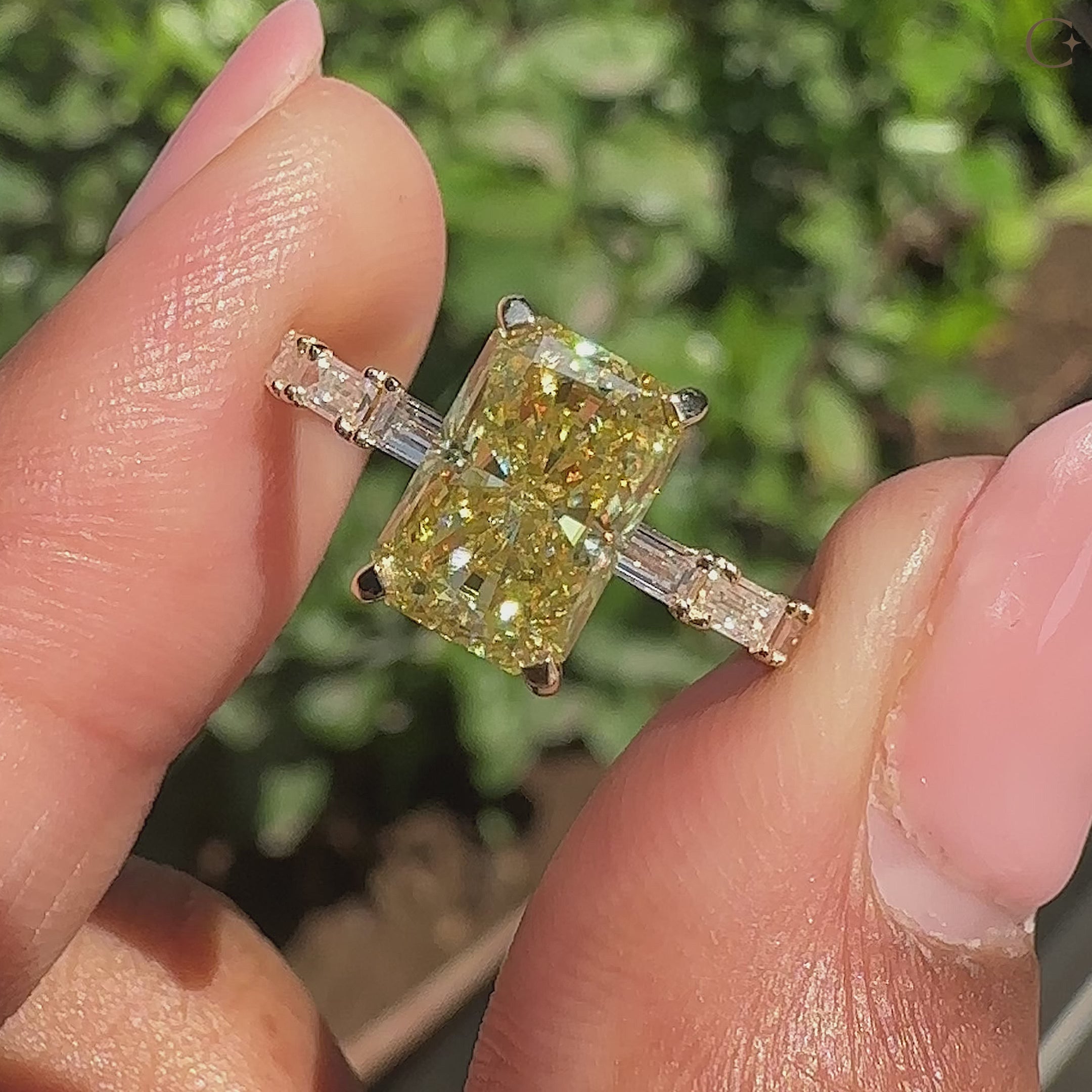 Radiant cut yellow moissanite engagement ring with baguette pave details.
