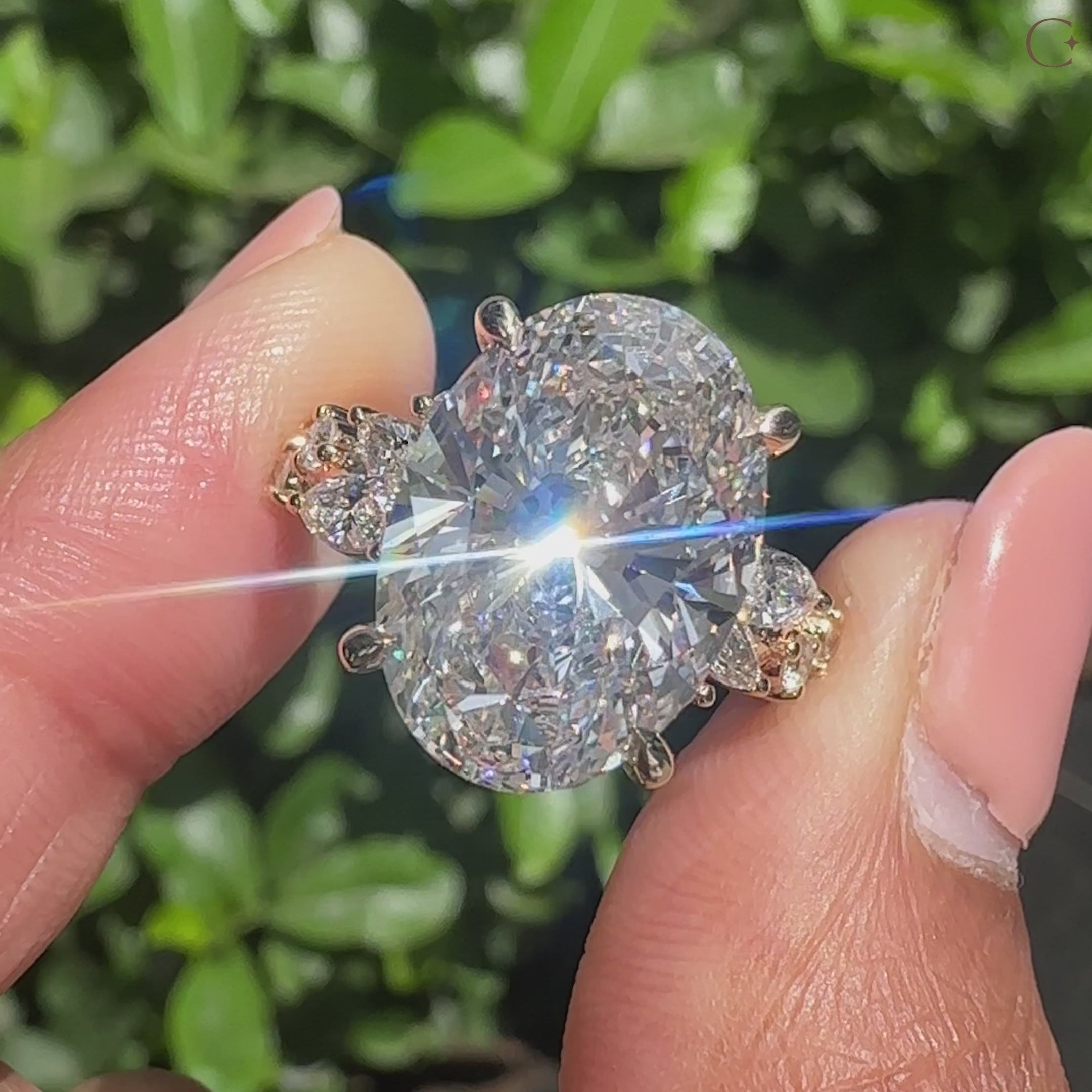 Lab grown oval cut diamond ring surrounded by marquise and round cluster accents.
