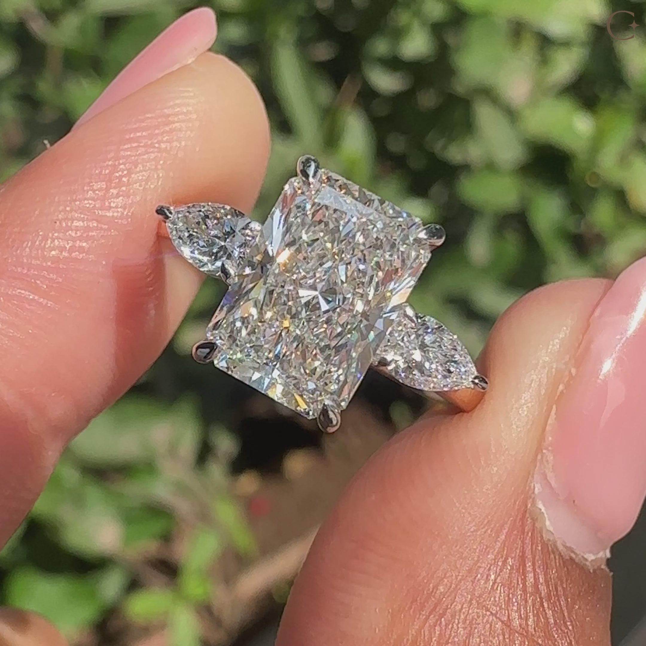 Three stone diamond ring with radiant cut center.
