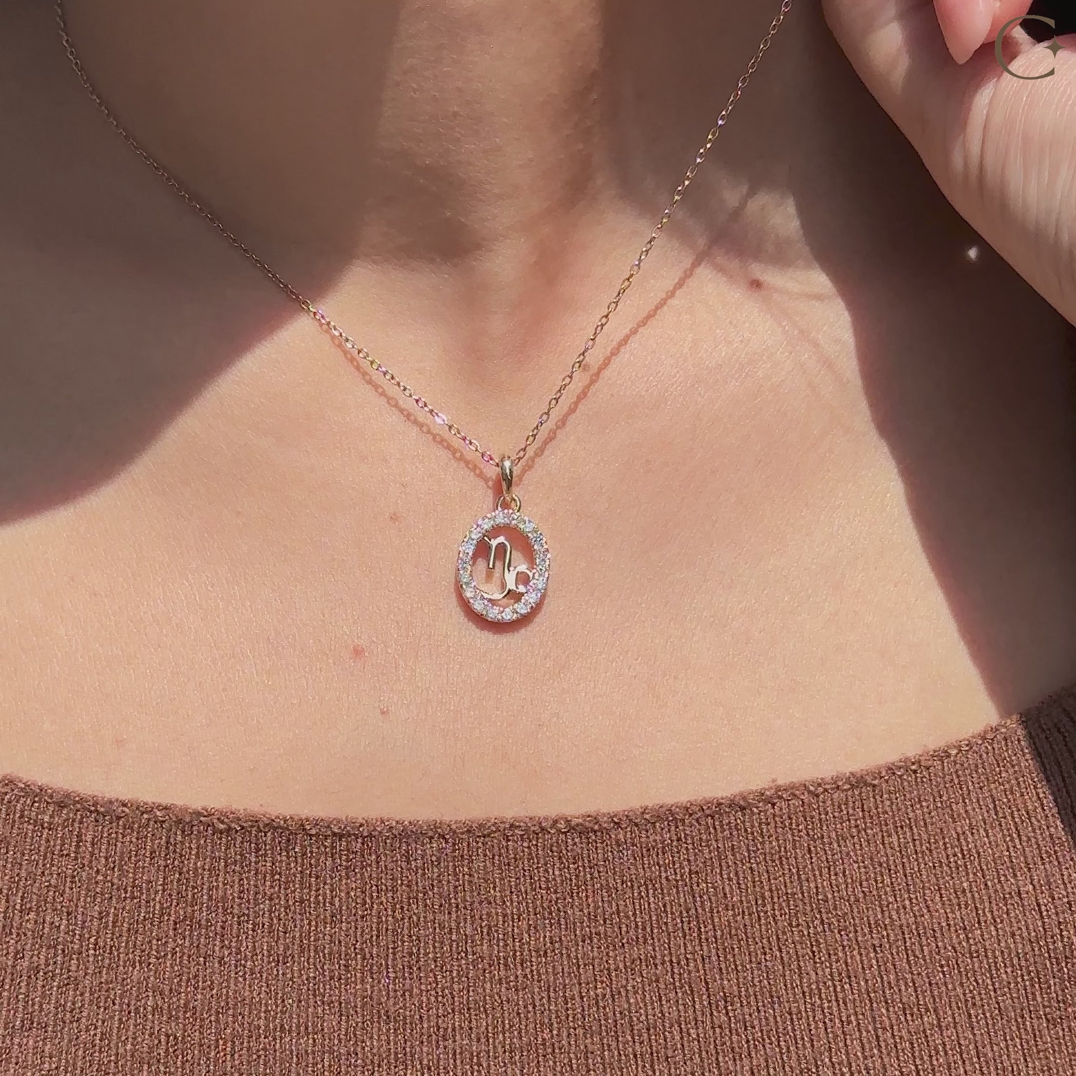 Crafted by Carat Diamonds, this handmade Capricorn pendant includes a round diamond halo.