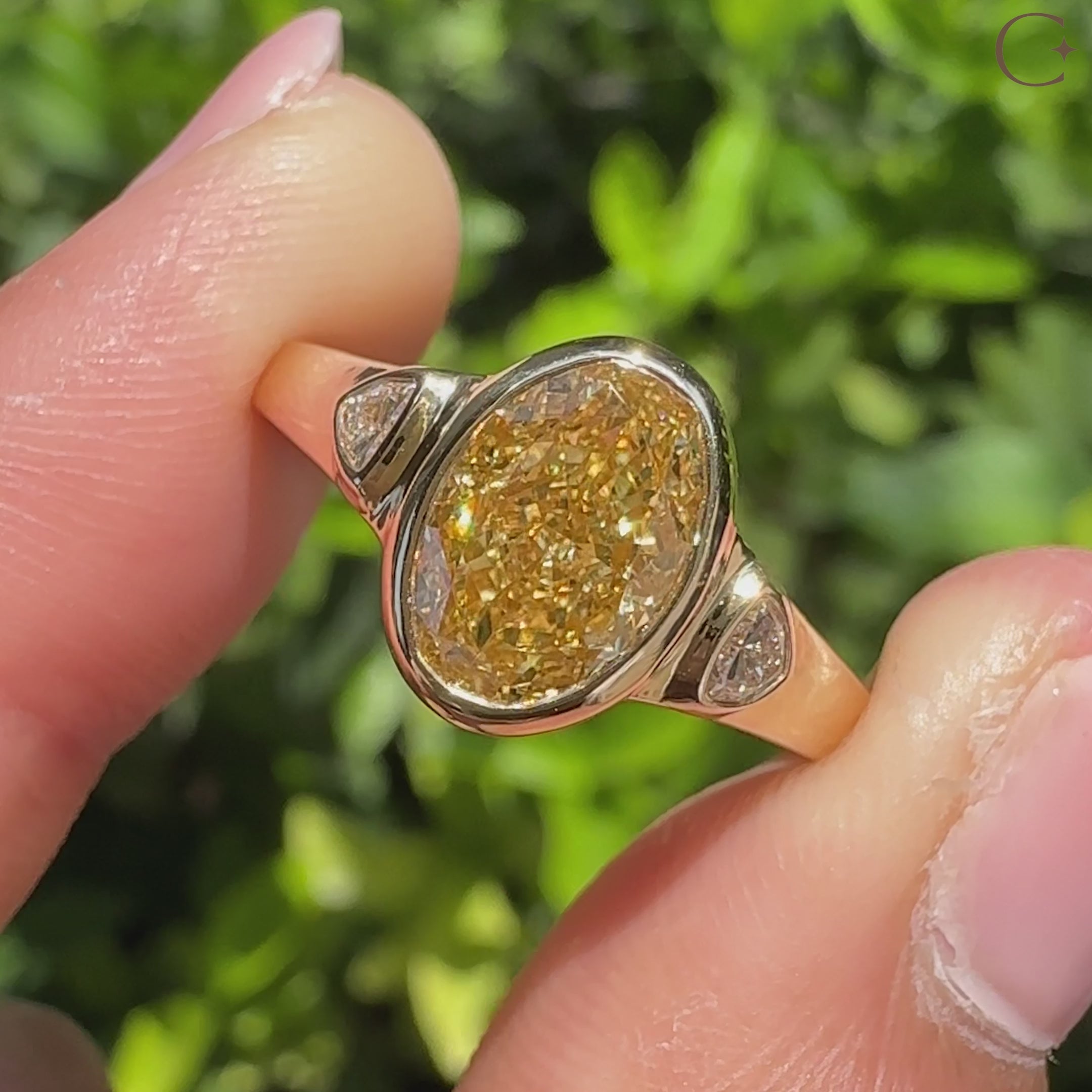 Oval diamond ring with trillion side stones and bezel
