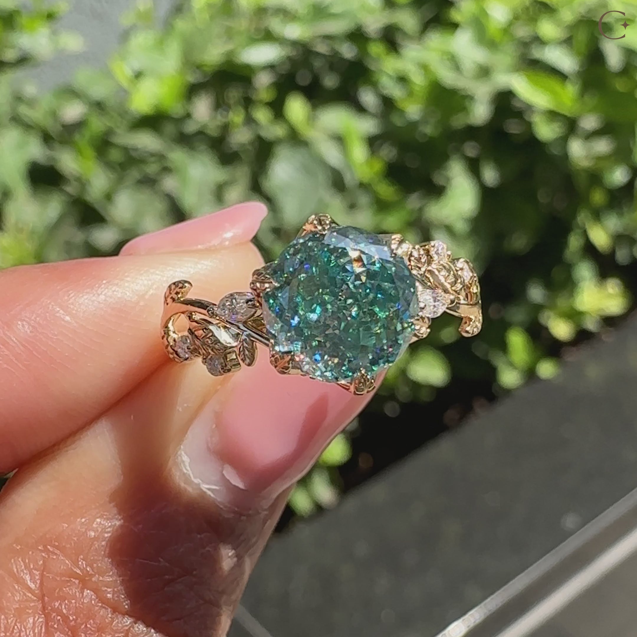 Cyan blue moissanite ring with tulip setting and side stones.
