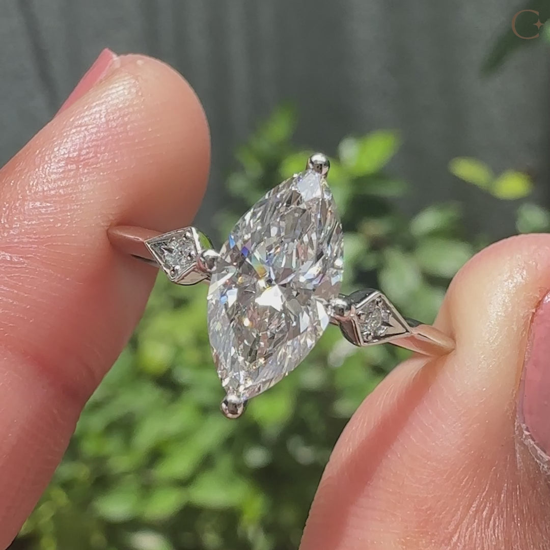 Kite shape outline ring with three stone engagement ring.