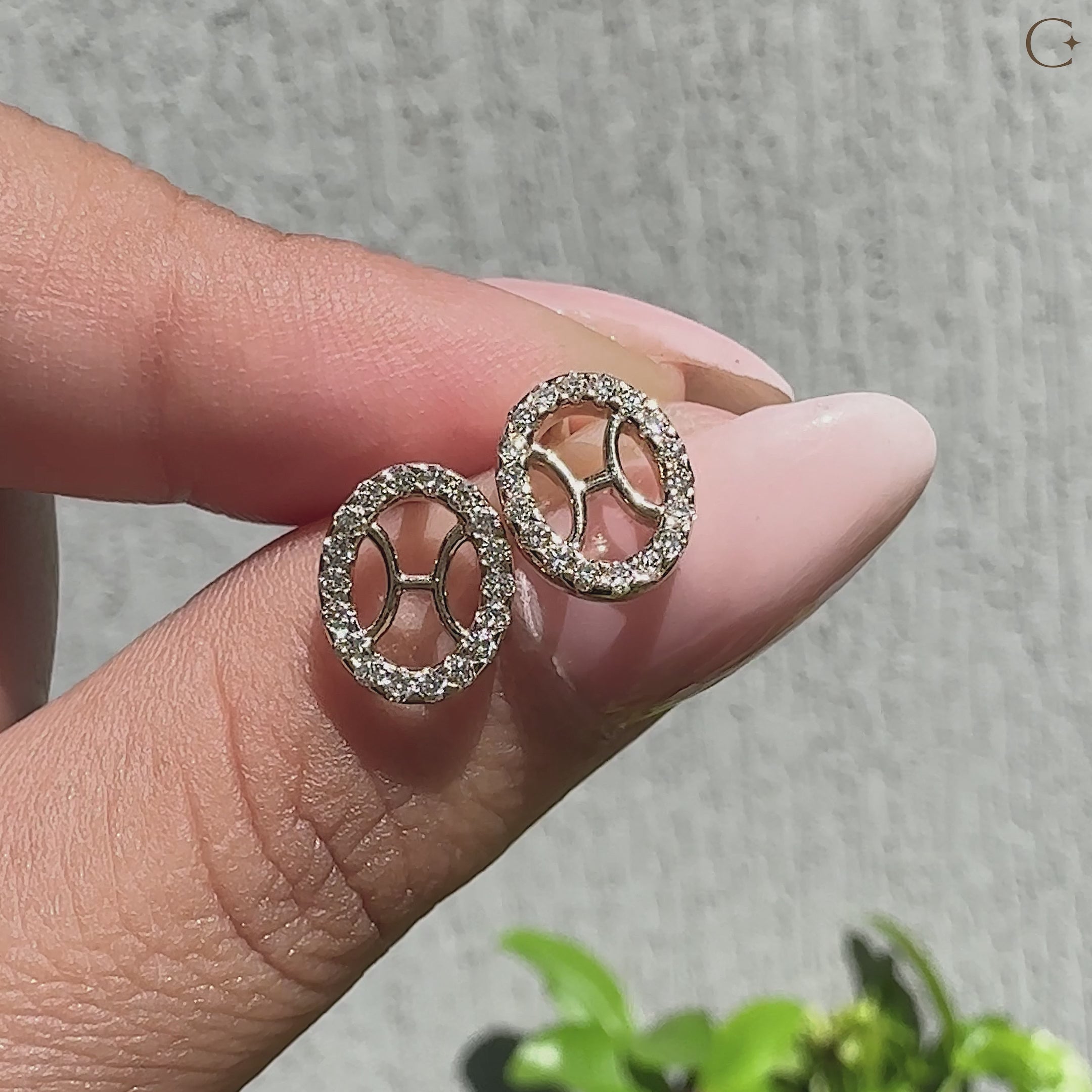 Handmade Pisces stud earrings featuring halo diamonds.
