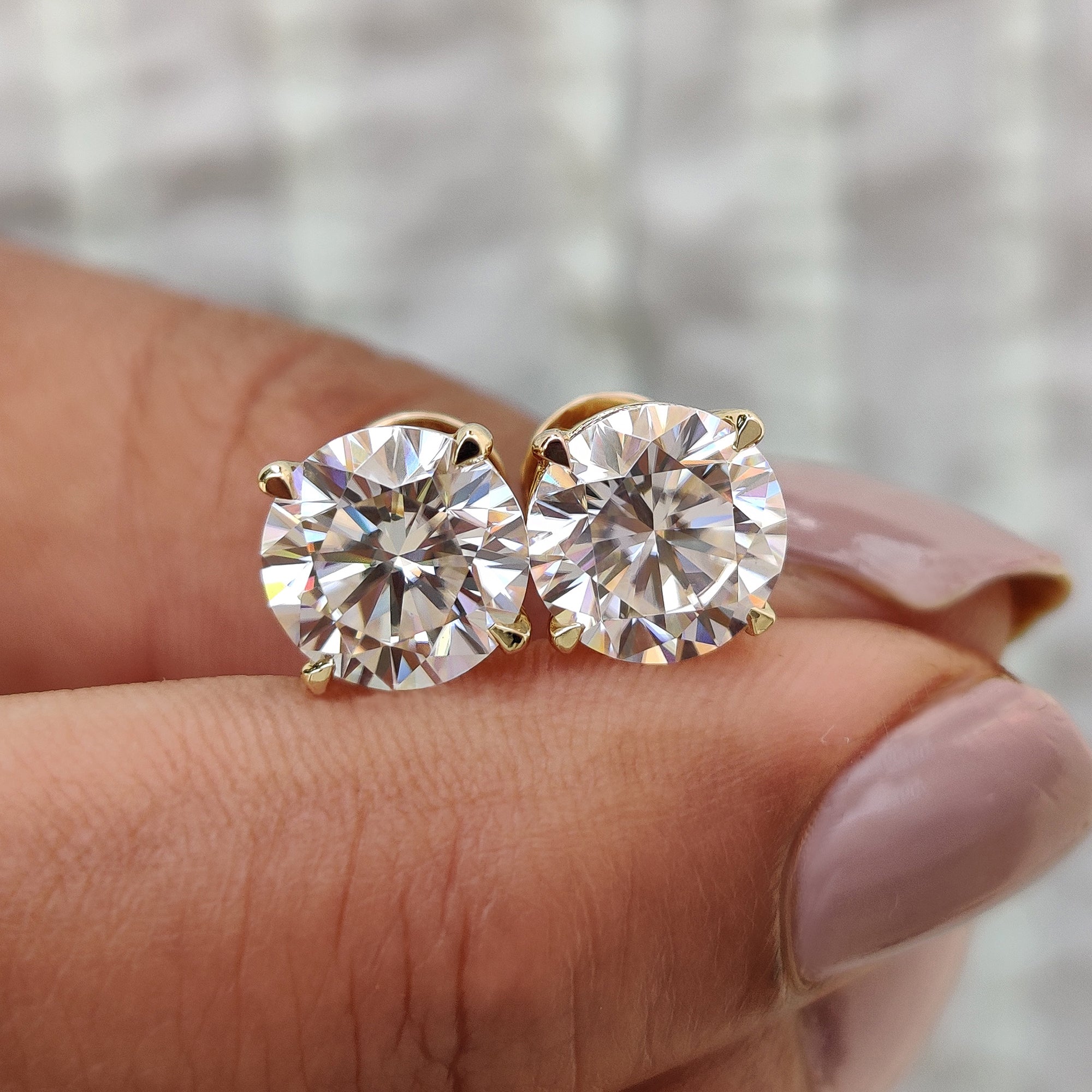 Round cut Moissanite Earrings made in yellow gold earrings with 4 claw prong setting.
