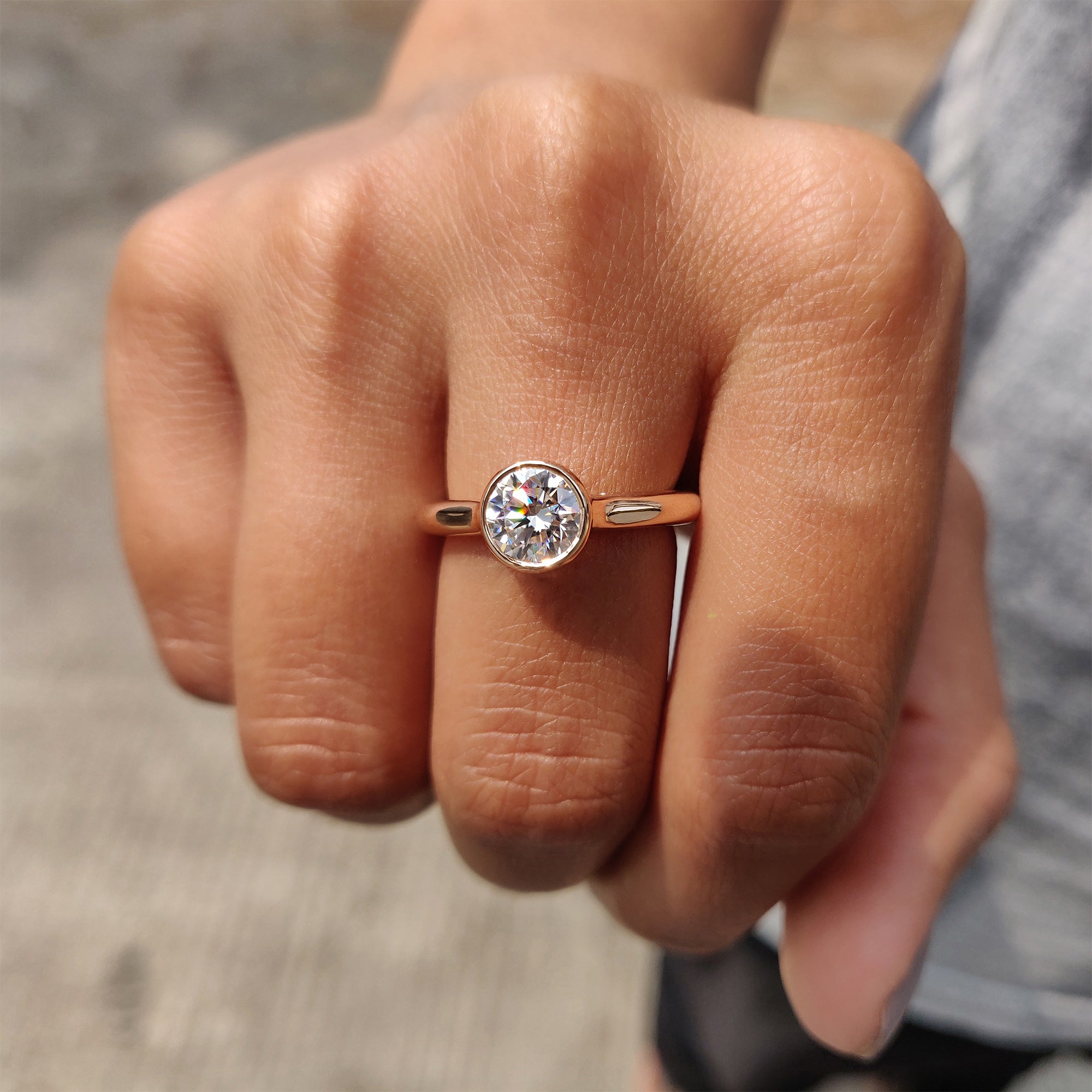 Bezel setting holding round cut moissanite.