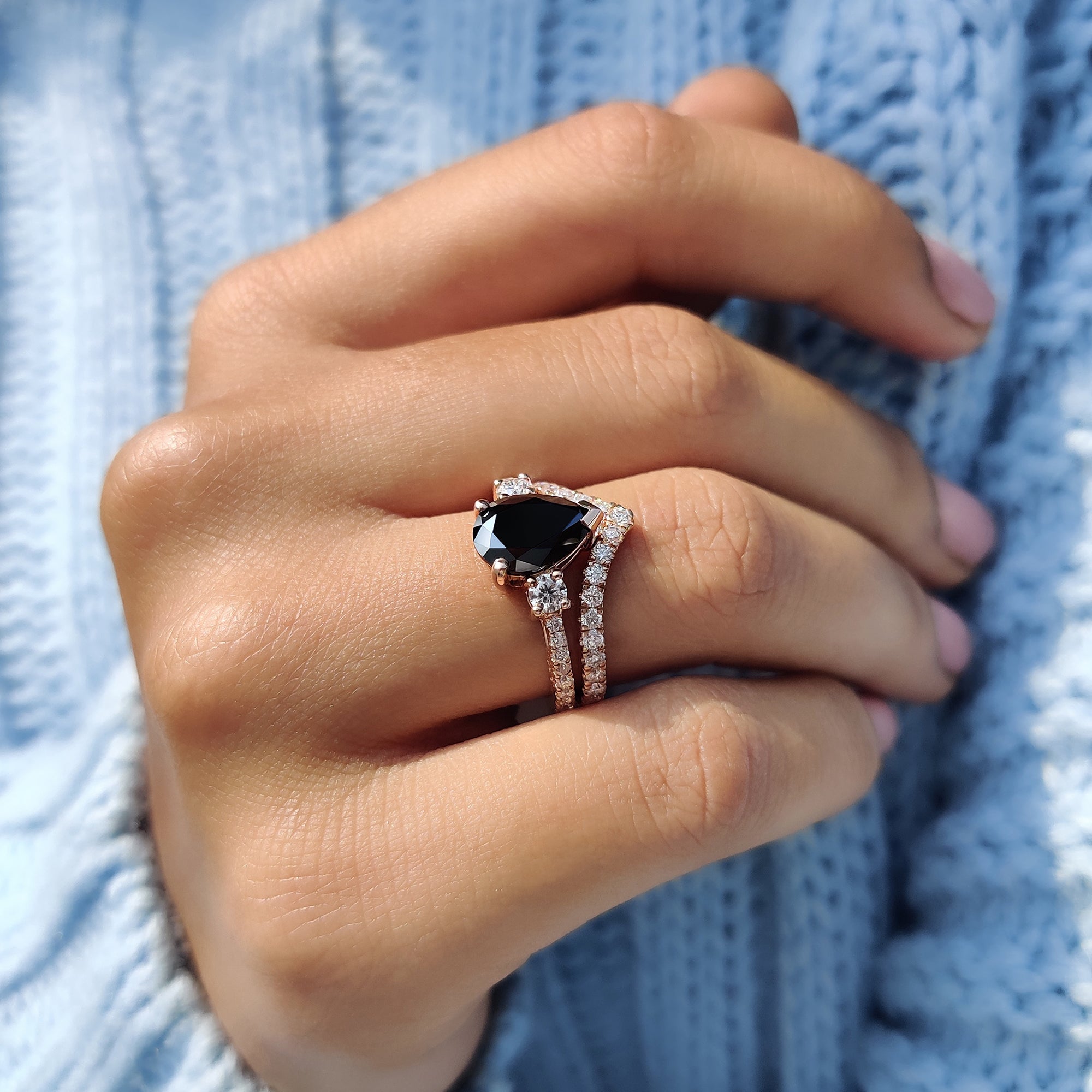 V prong setting on a black Moissanite ring with a curved wedding band.
