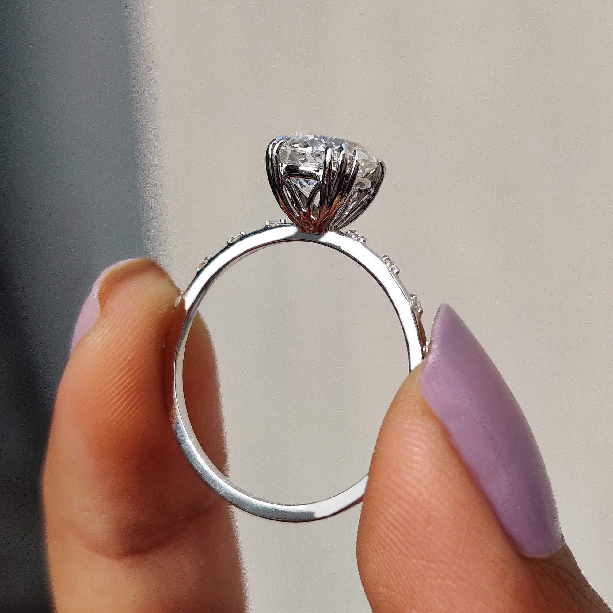 The white gold ring complements the moissanite's brilliance.
