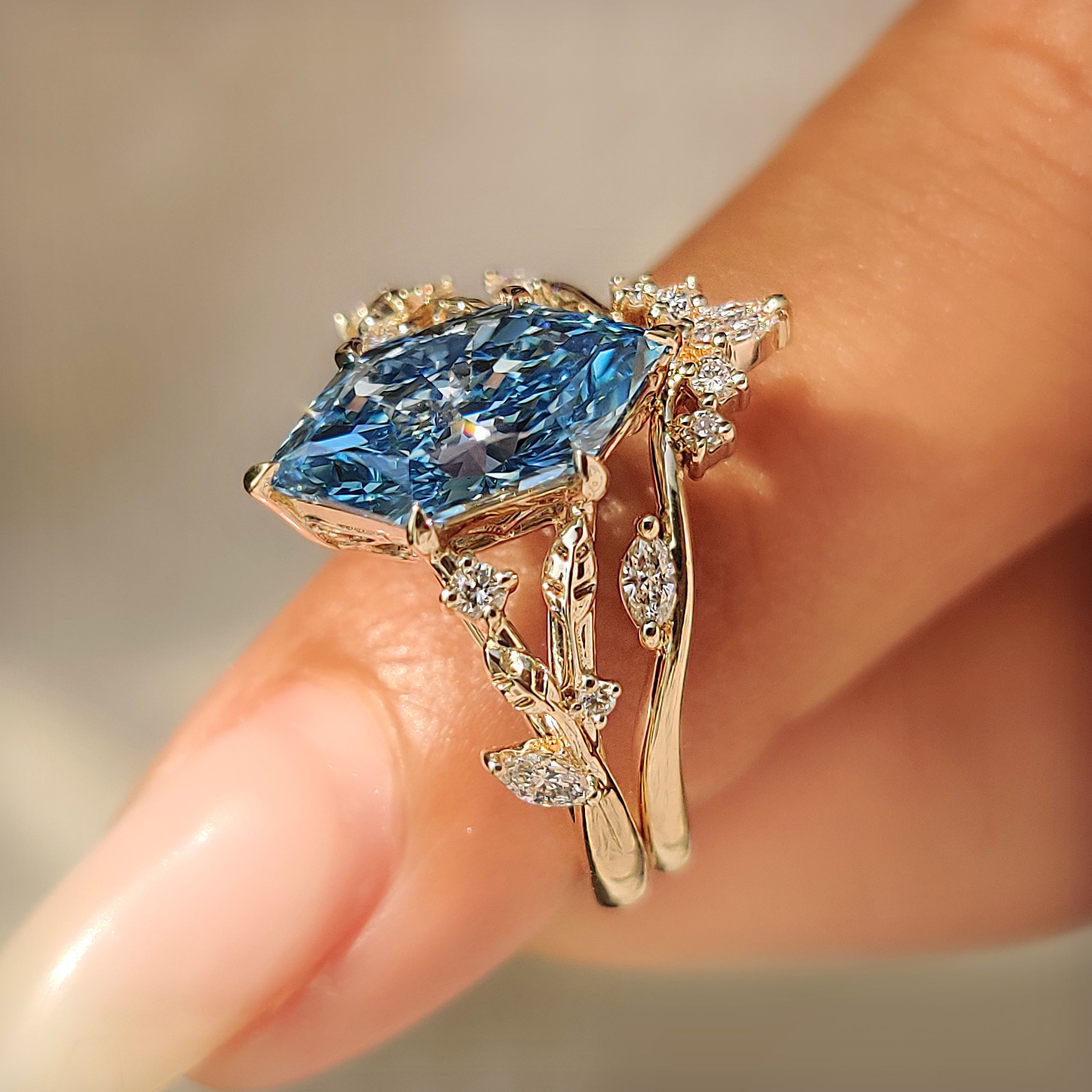 Blue Dutch marquise engagement ring with botanical leaf and vine accents.
