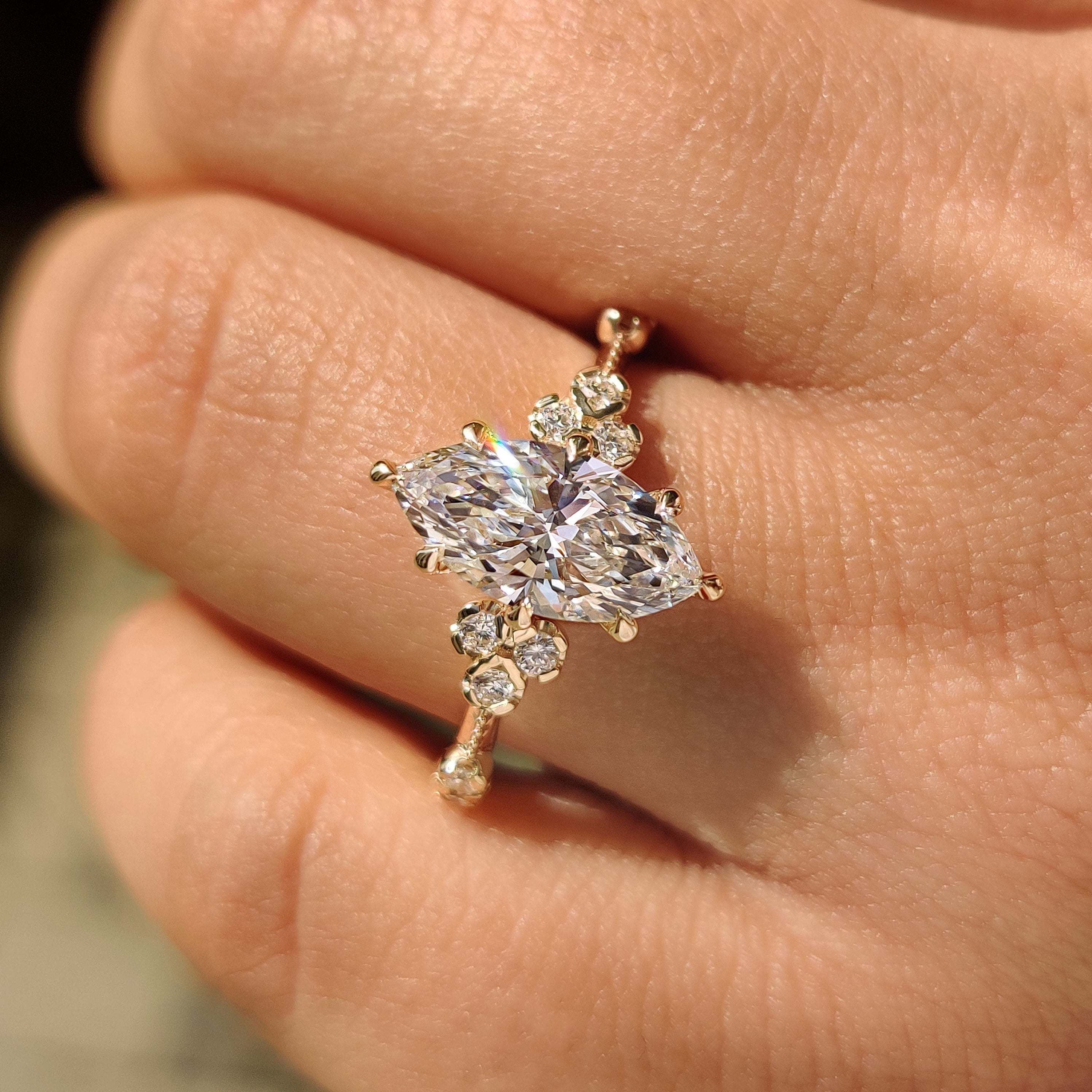 Marquise lab grown diamond ring with round side stones.
